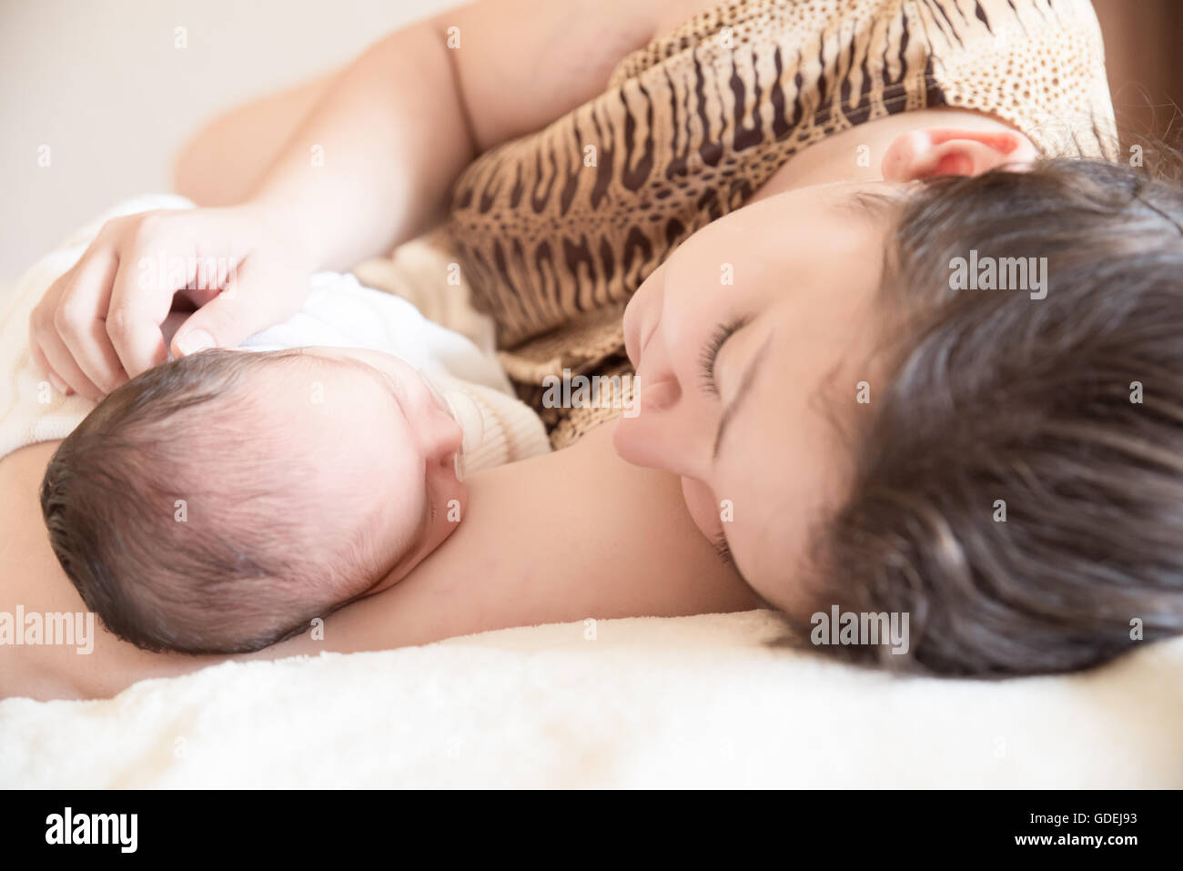 Mutter auf Bett liegend mit Neugeborenen Baby boy Stockfoto