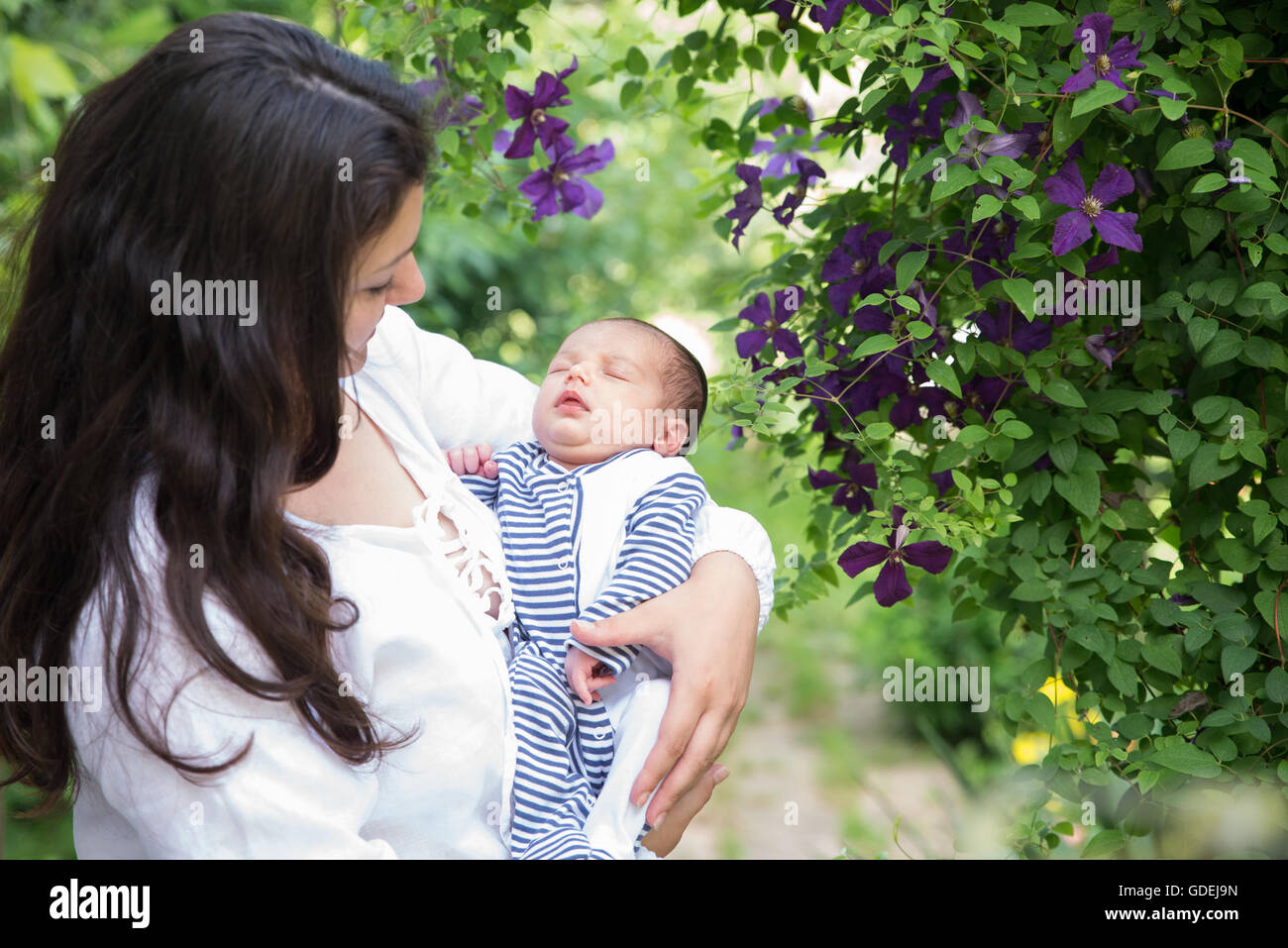 Mutter mit schlafenden Baby im Garten Stockfoto