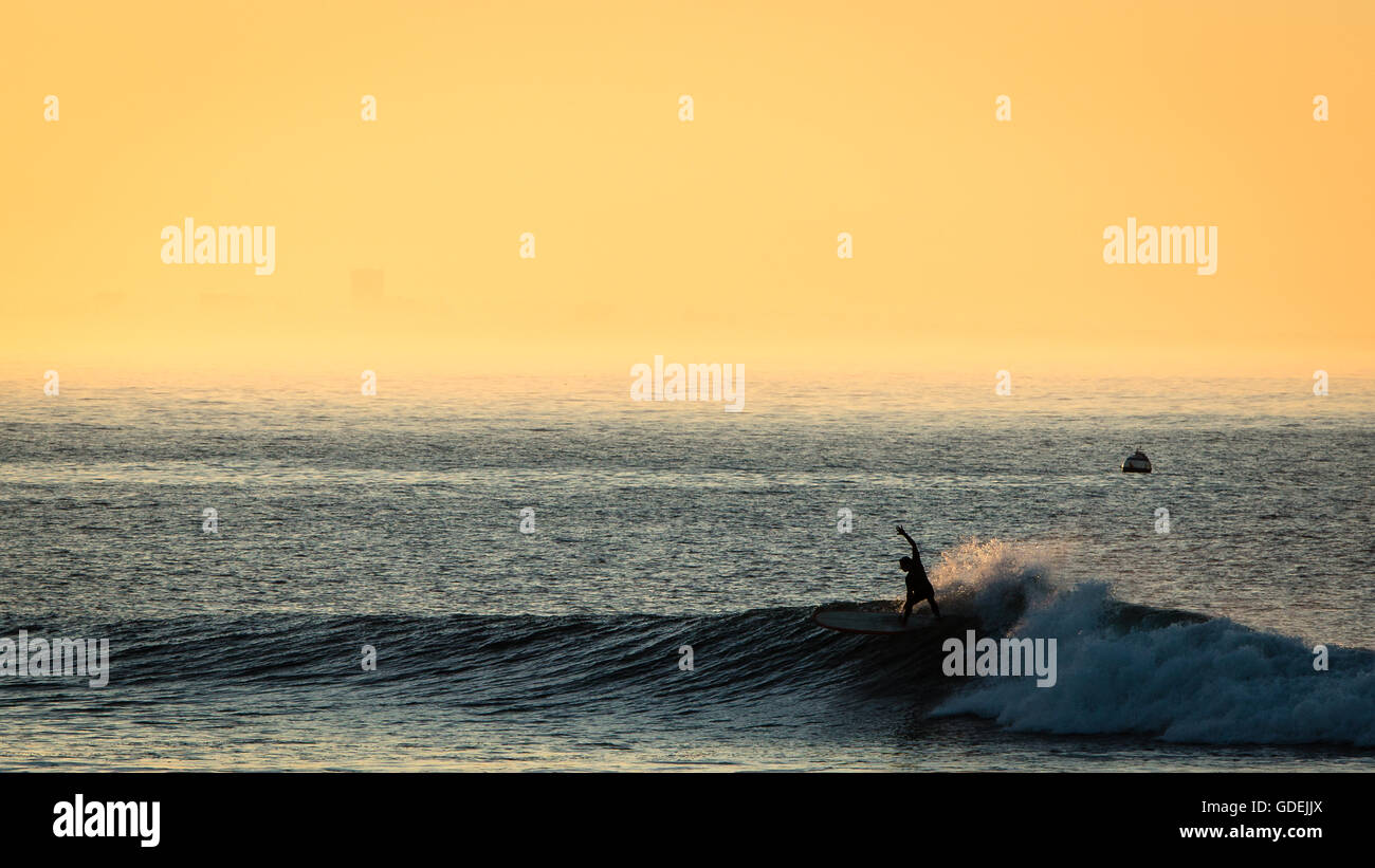 Silhouette eines Surfers tut eine Kürzung bei Sonnenaufgang, Malibu, California, Amerika, USA Stockfoto