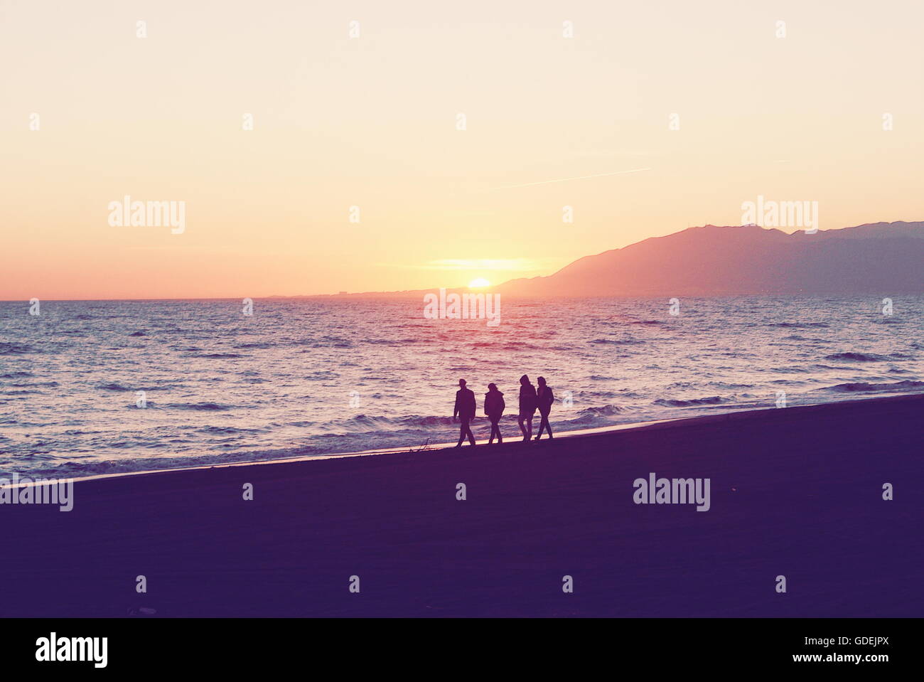 Silhouetten von vier Menschen Strand entlang, Malaga, Andalusien, Spanien Stockfoto
