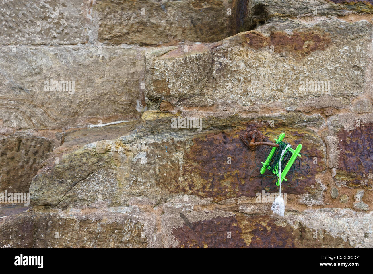 Eine grüne Hand Angelschnur auf einem alten Stein Hafen. Stockfoto