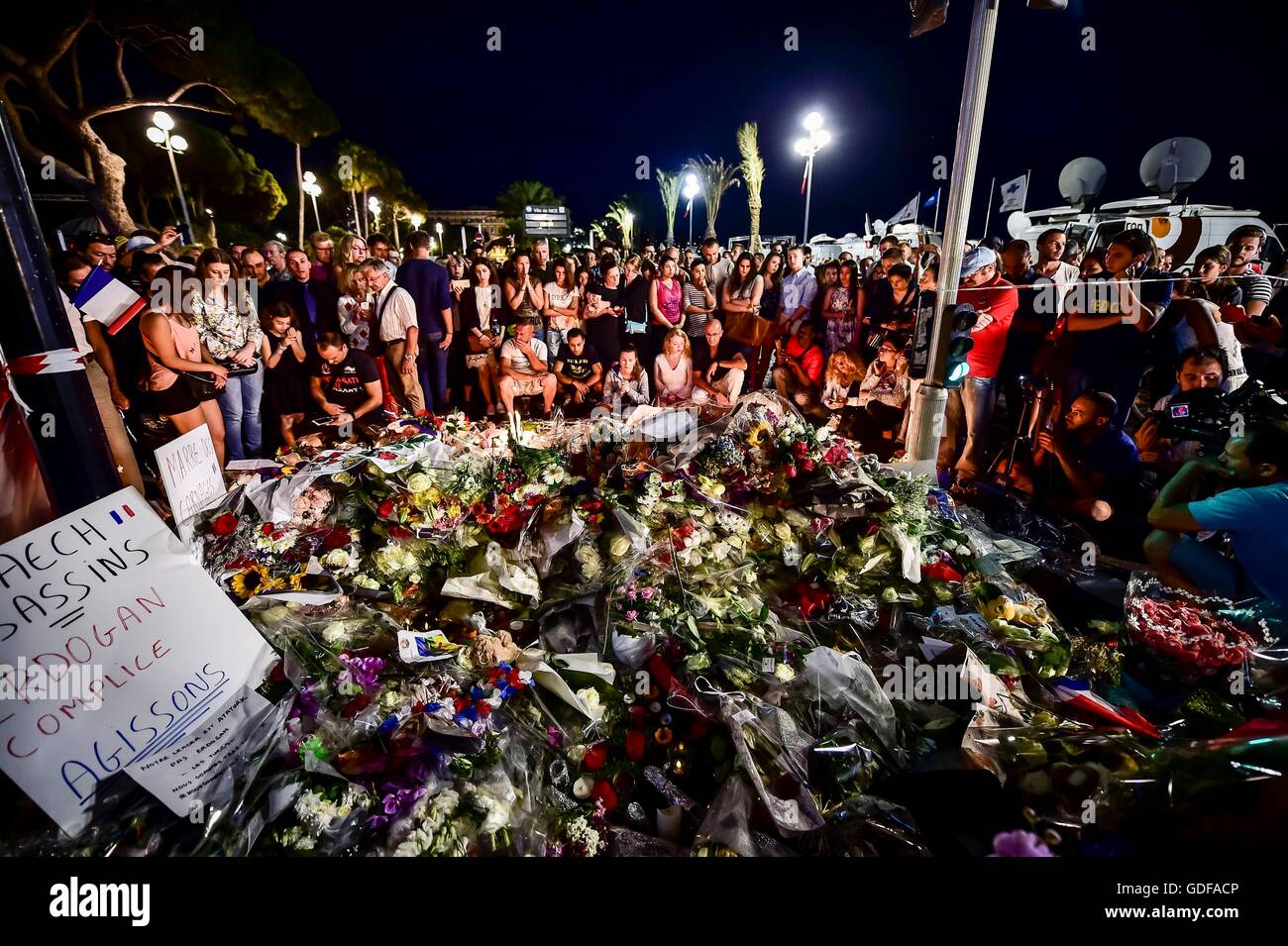 Menschen versammeln sich an der Promenade des Anglais, Nizza, als französische Detektive sind heute Abend versuchen, die Umstände zusammenzusetzen, die mindestens 84 Menschen tot verließ und Noten nach einem Terroristen absichtlich verletzt fuhr einen LKW in Meuterei auf der feiernden vor wird in eine Pattsituation mit bewaffneten Polizisten tödlich verwundet. Stockfoto