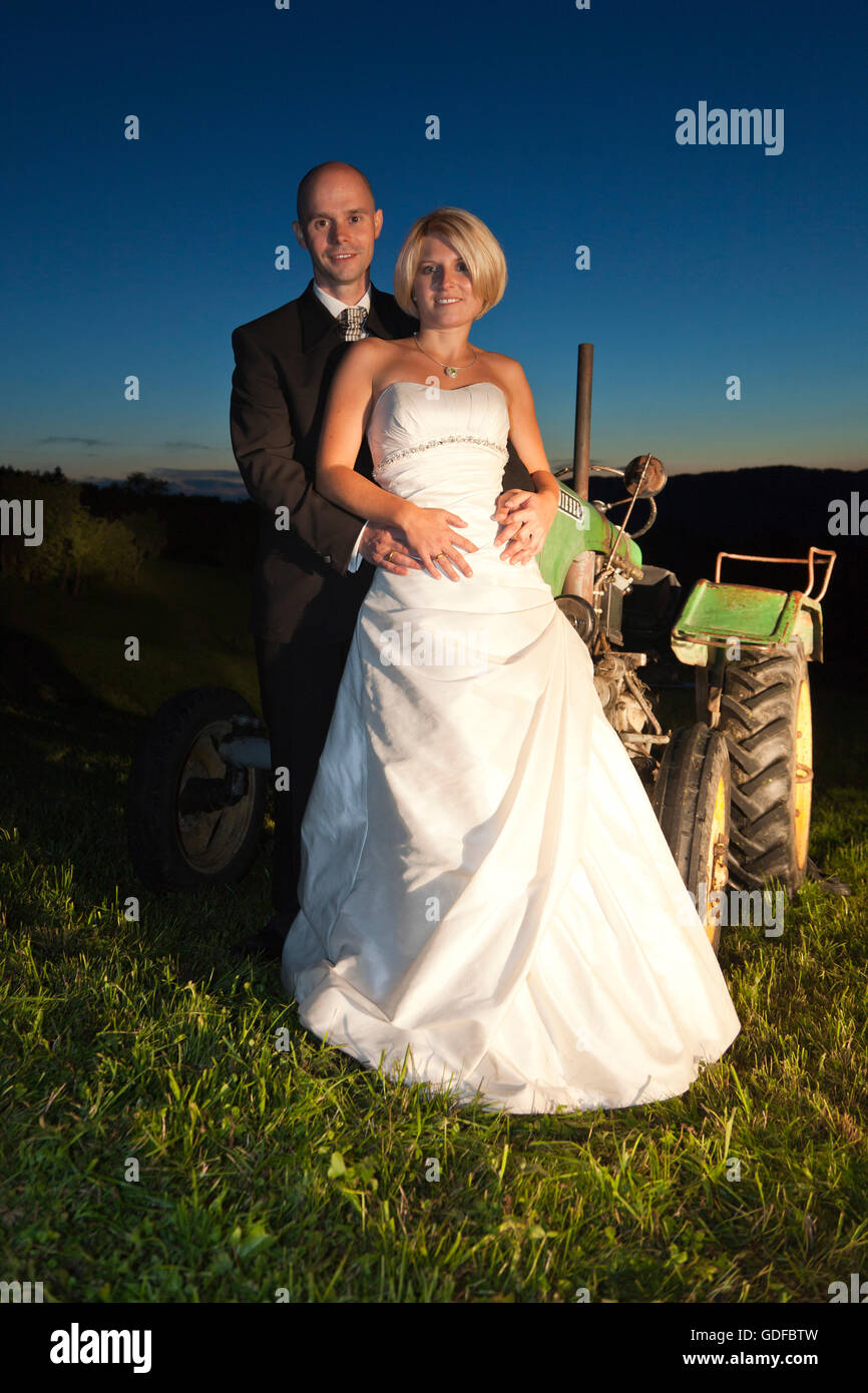 Glückliche Braut und Bräutigam stehen in einem Feld in der Dämmerung Stockfoto