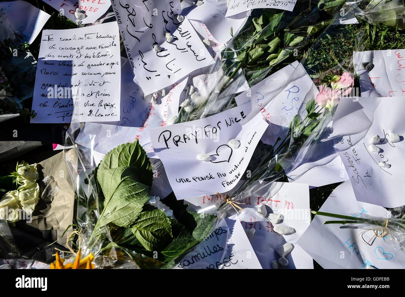 Eine Notiz zu sagen, "beten für Nizza" Links an eine Hommage an der Promenade des Anglais, Nizza, für 84 Tote und Partituren, nachdem ein Terrorist absichtlich einen Lastwagen in die Meuterei auf der feiernden fuhren, bevor er tödlich verwundet in eine Pattsituation mit bewaffneten Polizisten verletzt. Stockfoto