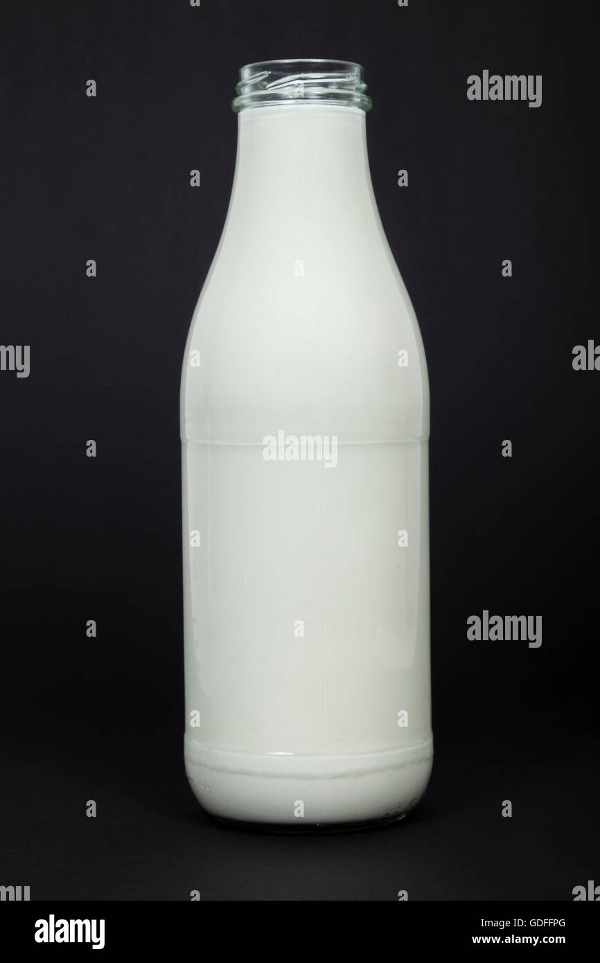 Milchflasche auf schwarzem Hintergrund Stockfoto