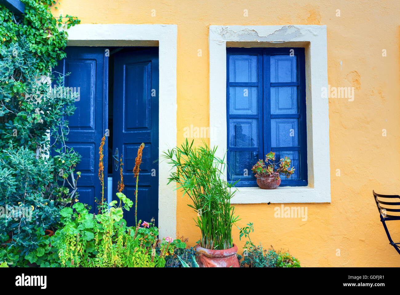 Altes Haus gelbe Wand mit blauen Türen und Fenstern. Griechenland-Santorini Stockfoto