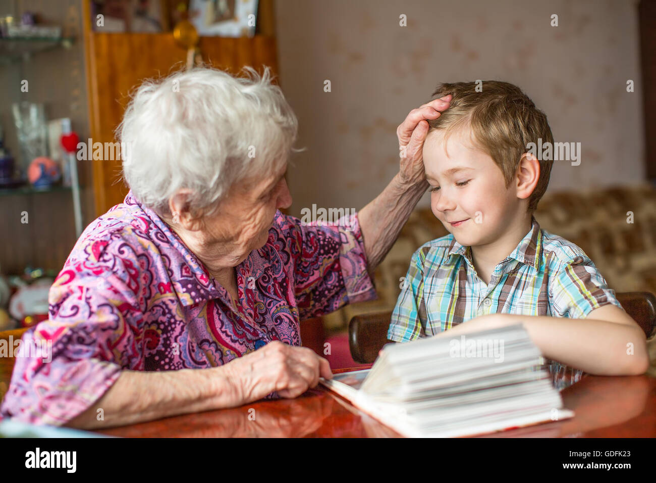 Oma zeigt Buch für kleine Enkel. Stockfoto