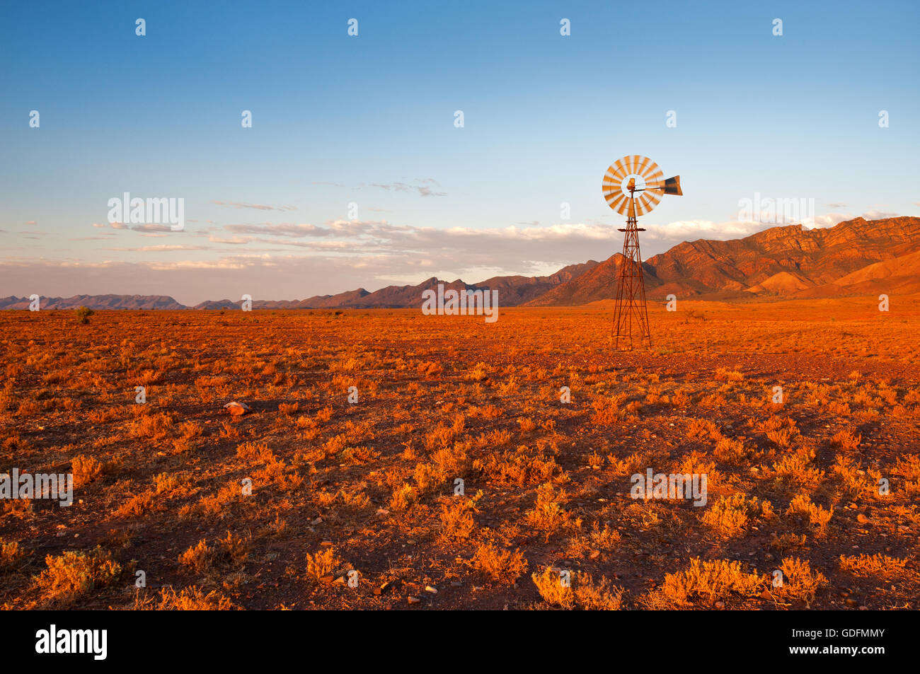 Typisch australisch - Windmühle im roten Farbton eines Sonnenuntergangs. Stockfoto