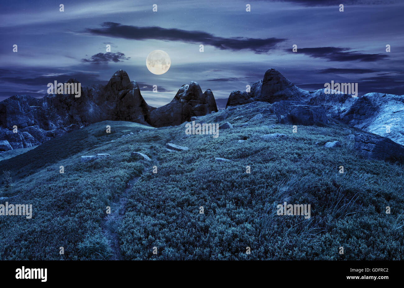 zusammengesetzte Landschaft mit Weg durch Hügel Wiese mit weißen Spitzen Felsbrocken in der Nähe von Cgi Berggipfel in der Nacht bei Vollmond li Stockfoto
