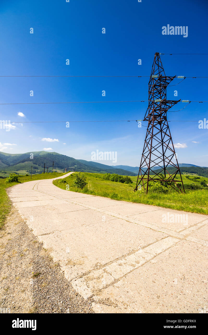 Elektrische Hochspannungsleitungen Turm in der Nähe von der Straße in Bergen Stockfoto