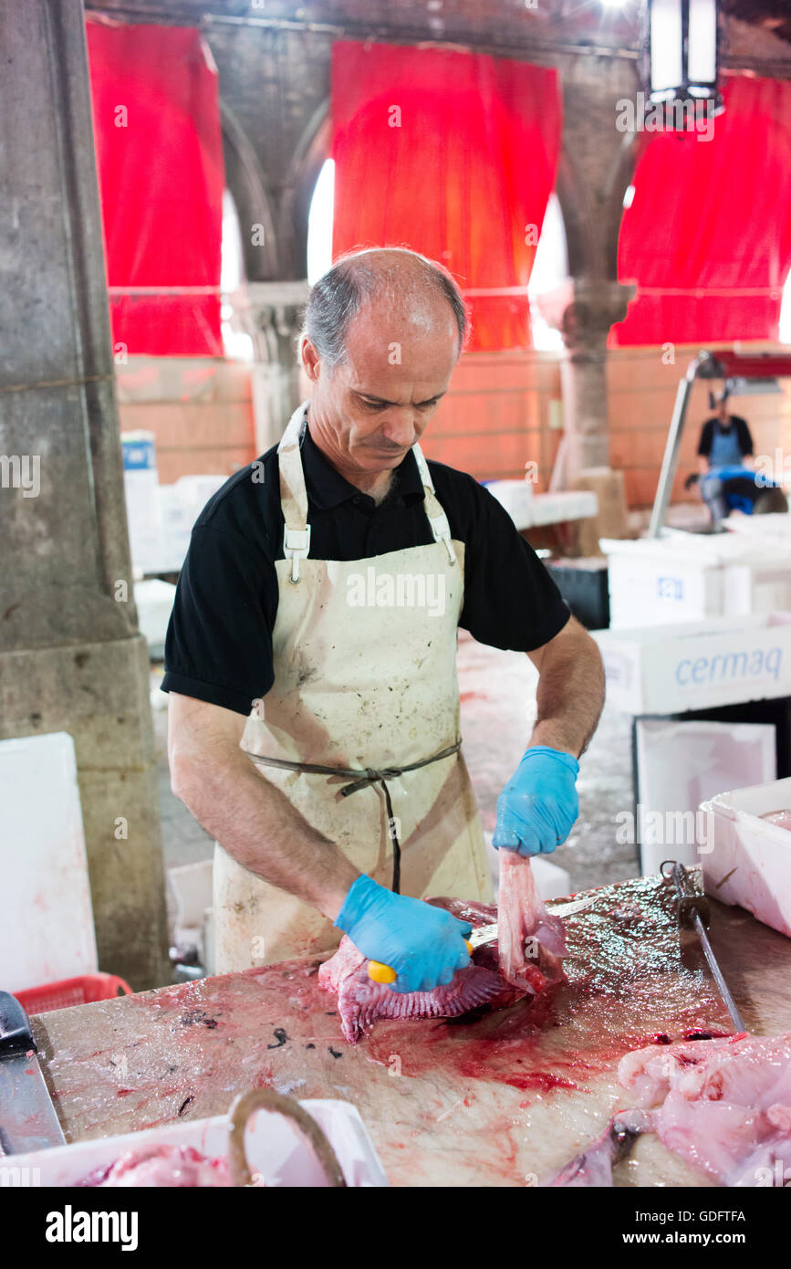 Mann bereitet Fisch zum Verkauf auf dem Rialto-Markt. Stockfoto