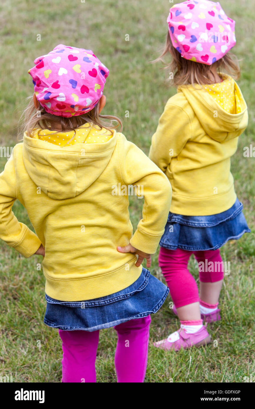 Zwillinge hinten, Mädchen in den gleichen Outfits Stockfoto