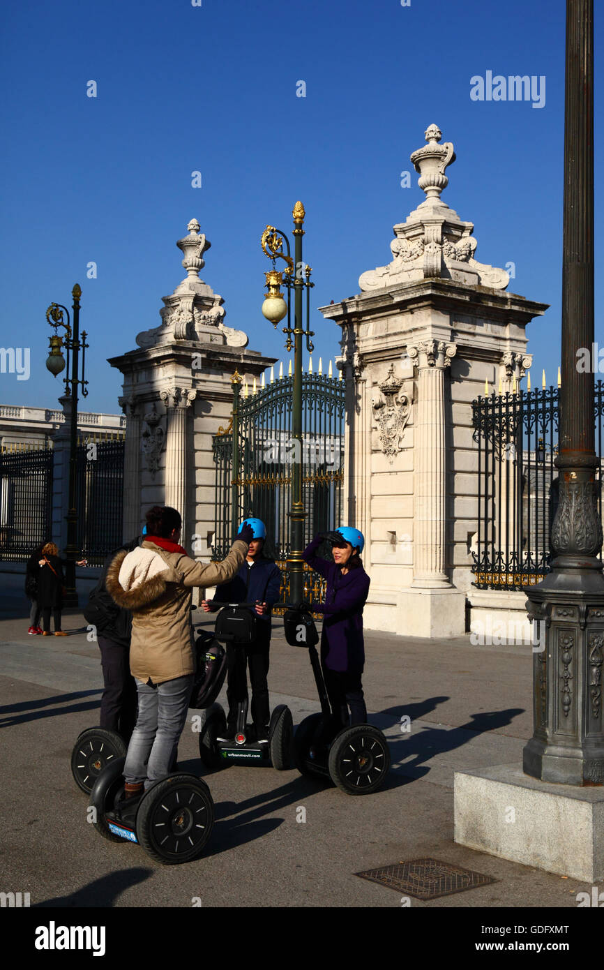 Asiatische Touristen auf Segway-Tour vor dem Haupttor der Königspalast, Plaza De La Armeria, Madrid, Spanien Stockfoto