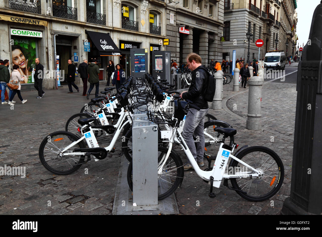 Mann, die Anmietung eines BiciMAD-Elektro-Fahrrads an einer Docking-Station am Plaza Puerta del Sol, Madrid, Spanien Stockfoto