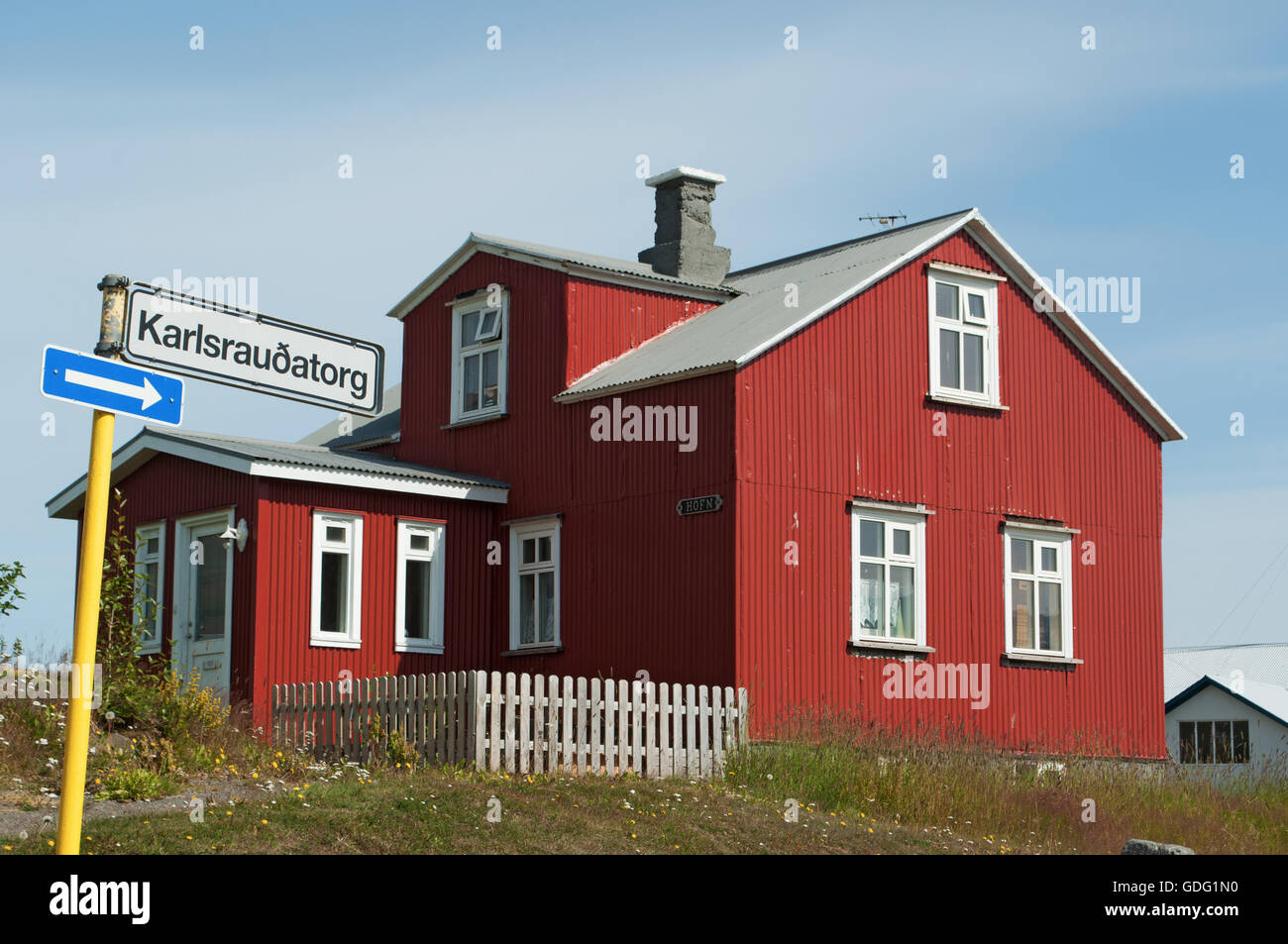 Island: ein rotes Holzhaus in isländischen Landschaft. Bunte Holzhäuser sind eines der wichtigsten Merkmale der nordischen Architektur Stockfoto