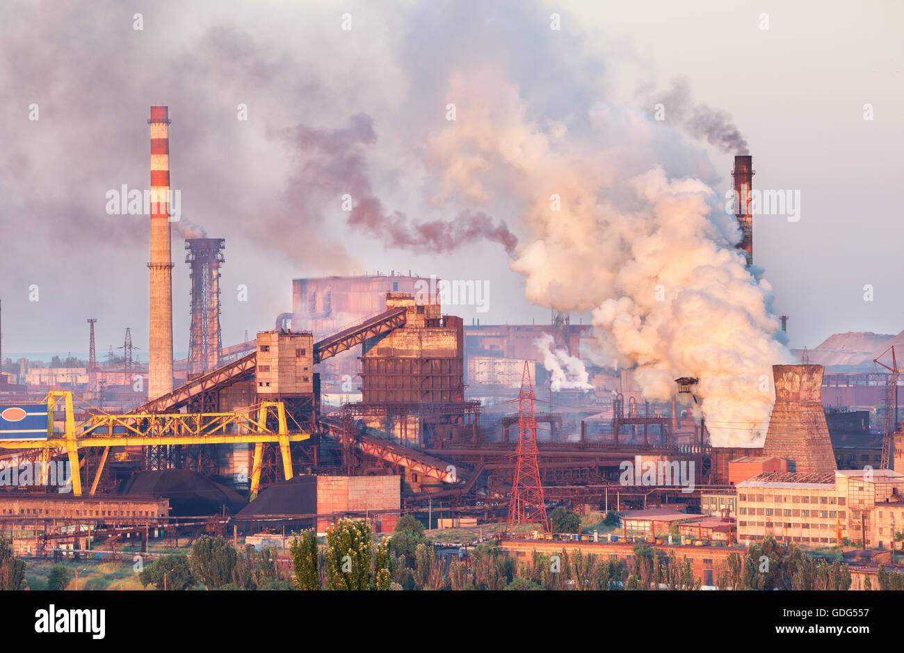 Industrielandschaft in der Ukraine. Stahlwerk bei Sonnenuntergang. Rohre mit Rauch. Metallurgische Fabrik. Stahlwerke, Eisenhütte. Schwere ich Stockfoto