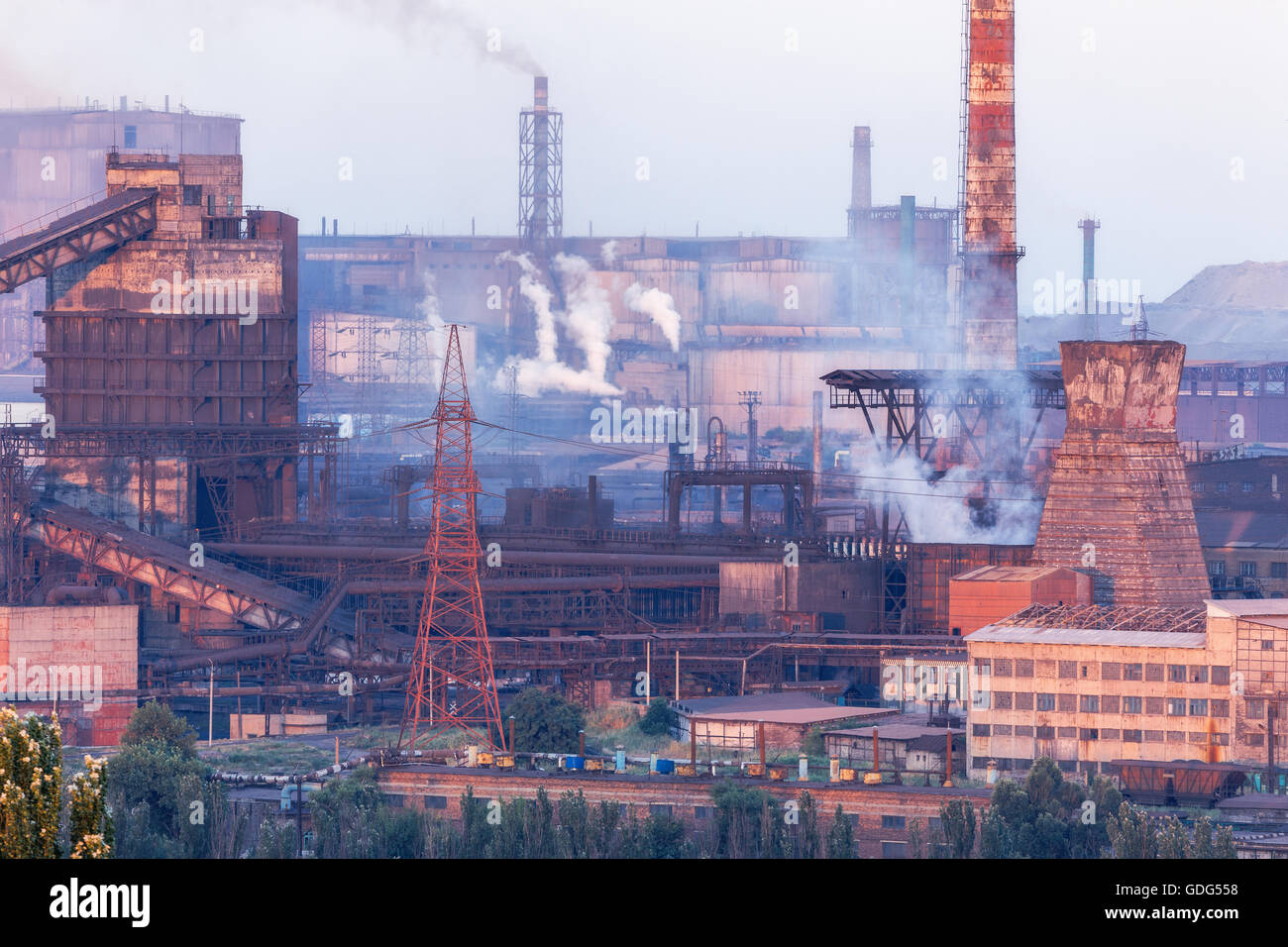 Industrielandschaft in der Ukraine. Stahlwerk bei Sonnenuntergang. Rohre mit Rauch. Metallurgische Fabrik. Stahlwerke, Eisenhütte. Schwere ich Stockfoto