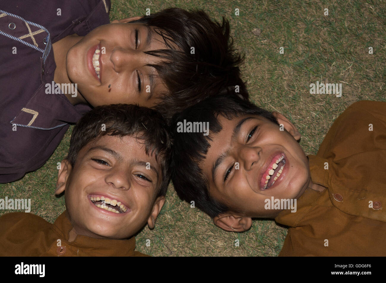 drei Kinder erfreuen sich und übergeben Sie Lächeln Stockfoto