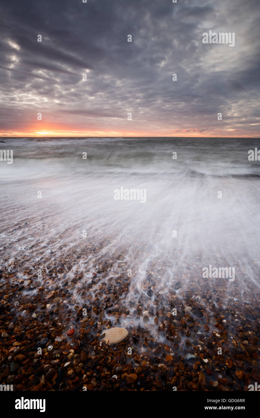 Verschwommene Rückspülung bei der Kiesstrand am Seaton Schleuse, Collywell Bucht Stockfoto