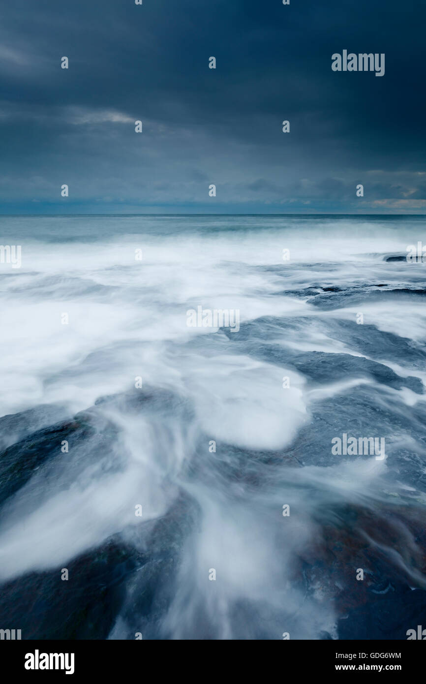 zurückweichenden Wellen an einem stürmischen Abend in der Nähe von Craster Stockfoto