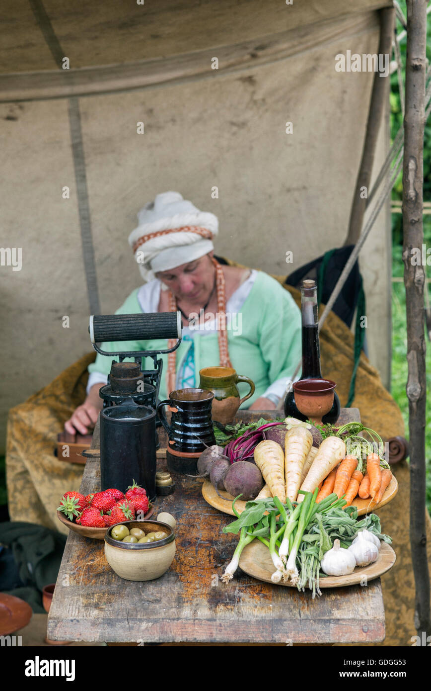 Mittelalterliche Frau Reenactor und Tabelle von Lebensmitteln bei Tewkesbury mittelalterlichen Festspielen 2016, Gloucestershire, England. Stockfoto