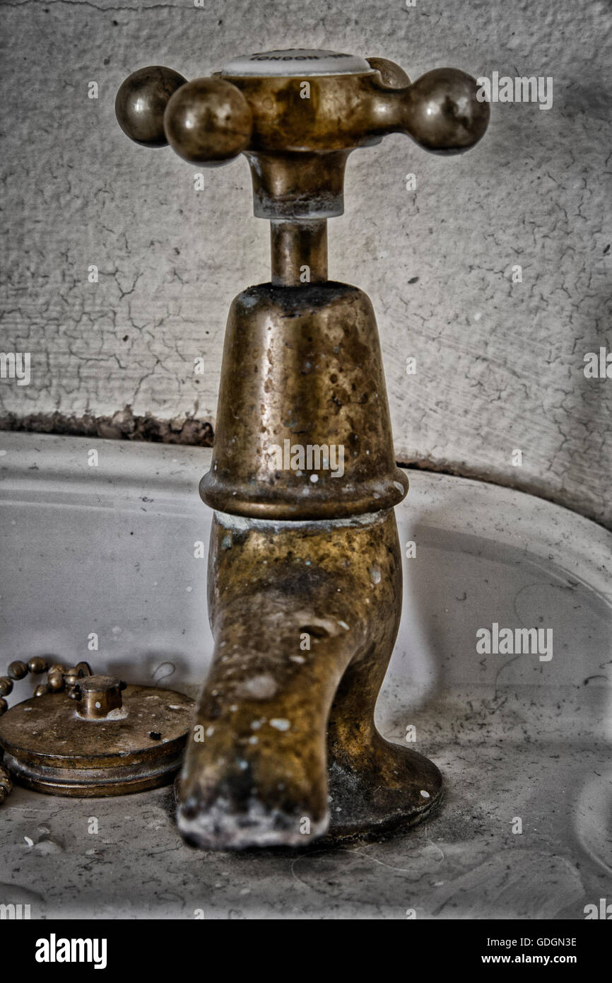 Korrodierte Messing Hahn auf einem alten Waschbecken Stockfoto