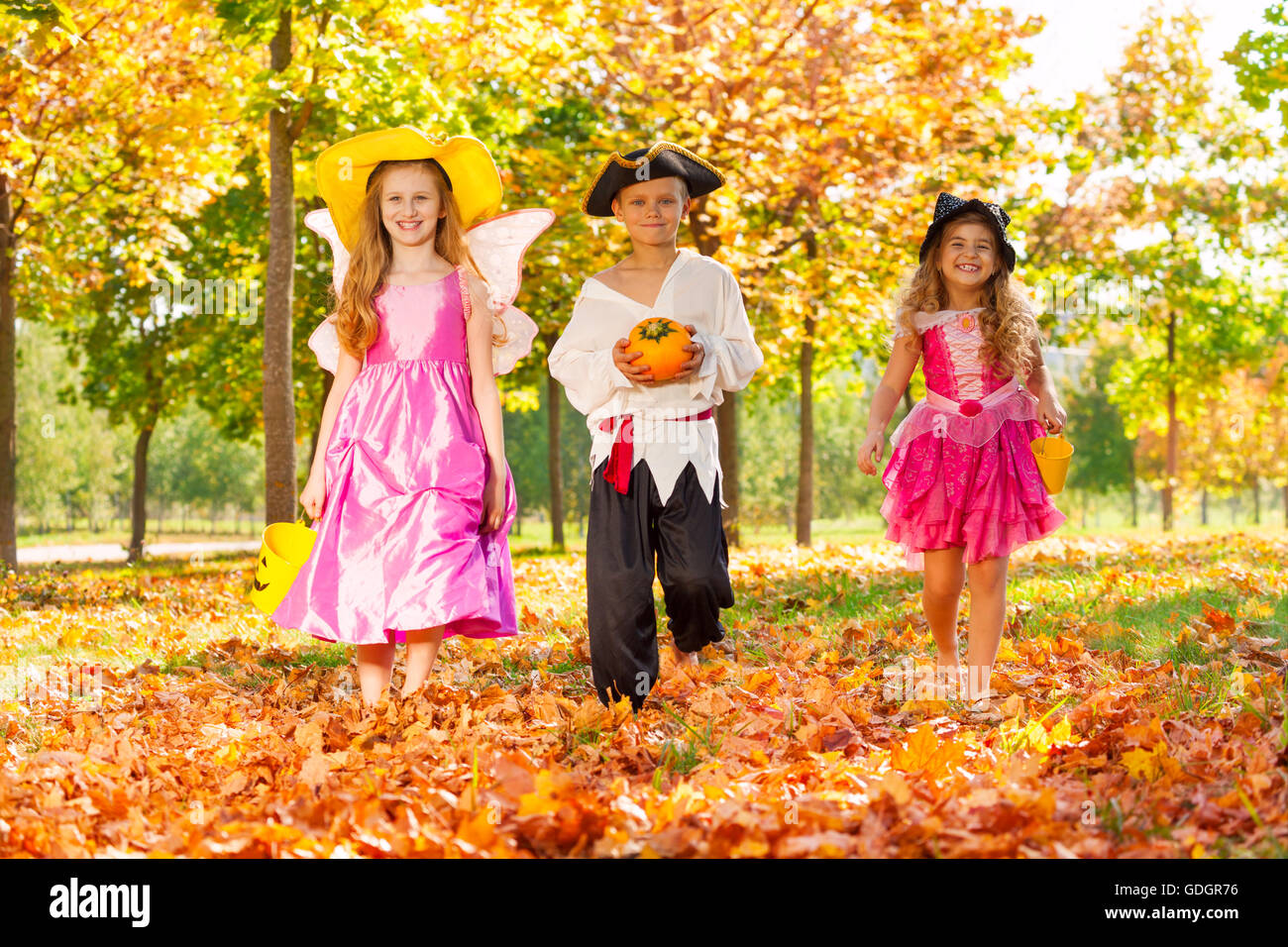 Glückliche Kinder in Halloween-Kostümen zu Fuß Stockfoto