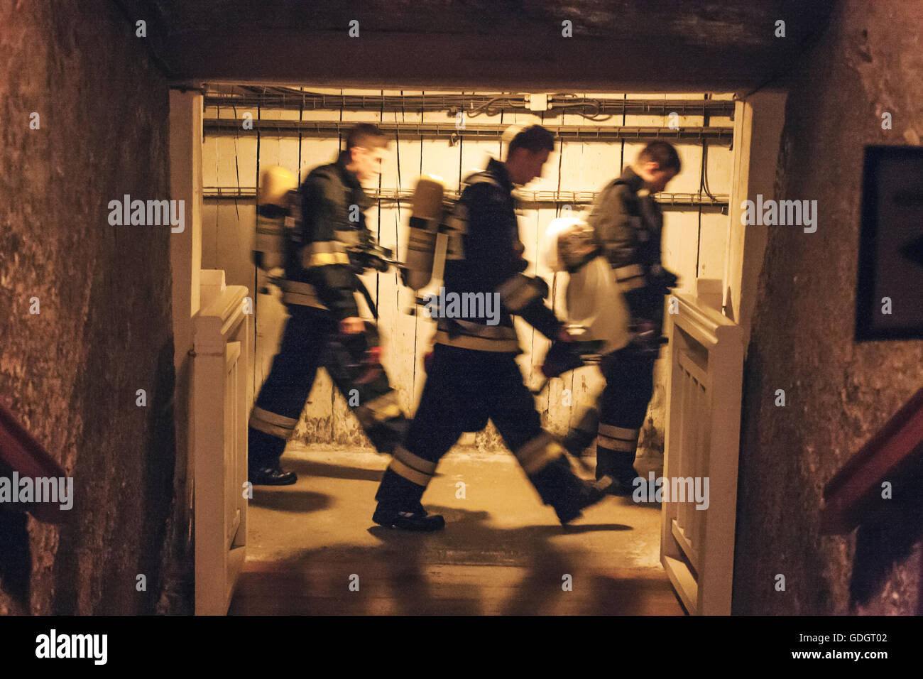 Drei müde polnischen Feuerwehrleute, die durch die offene Tür im Keller Stockfoto