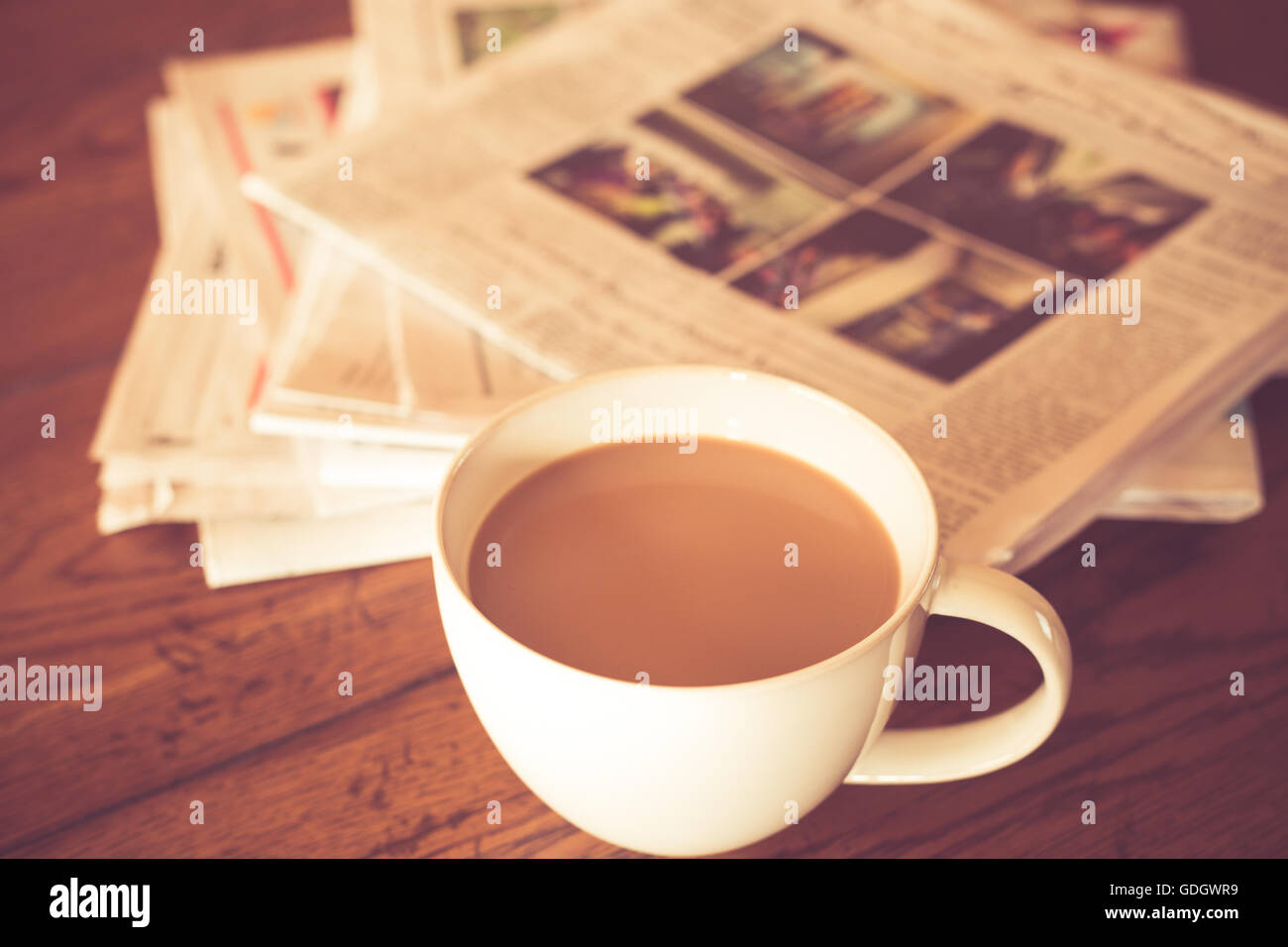 Tasse Kaffee und Zeitung mit warmen Vintage-Ton Stockfoto