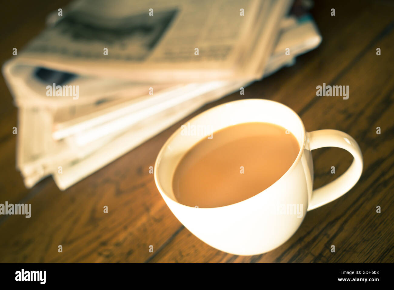 Tasse Kaffee und Zeitung mit warmen Vintage-Ton Stockfoto