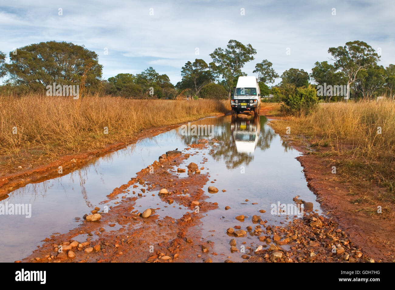 Das Wasser über eine unbefestigte Straße nach etwas Regen im Outback. Stockfoto