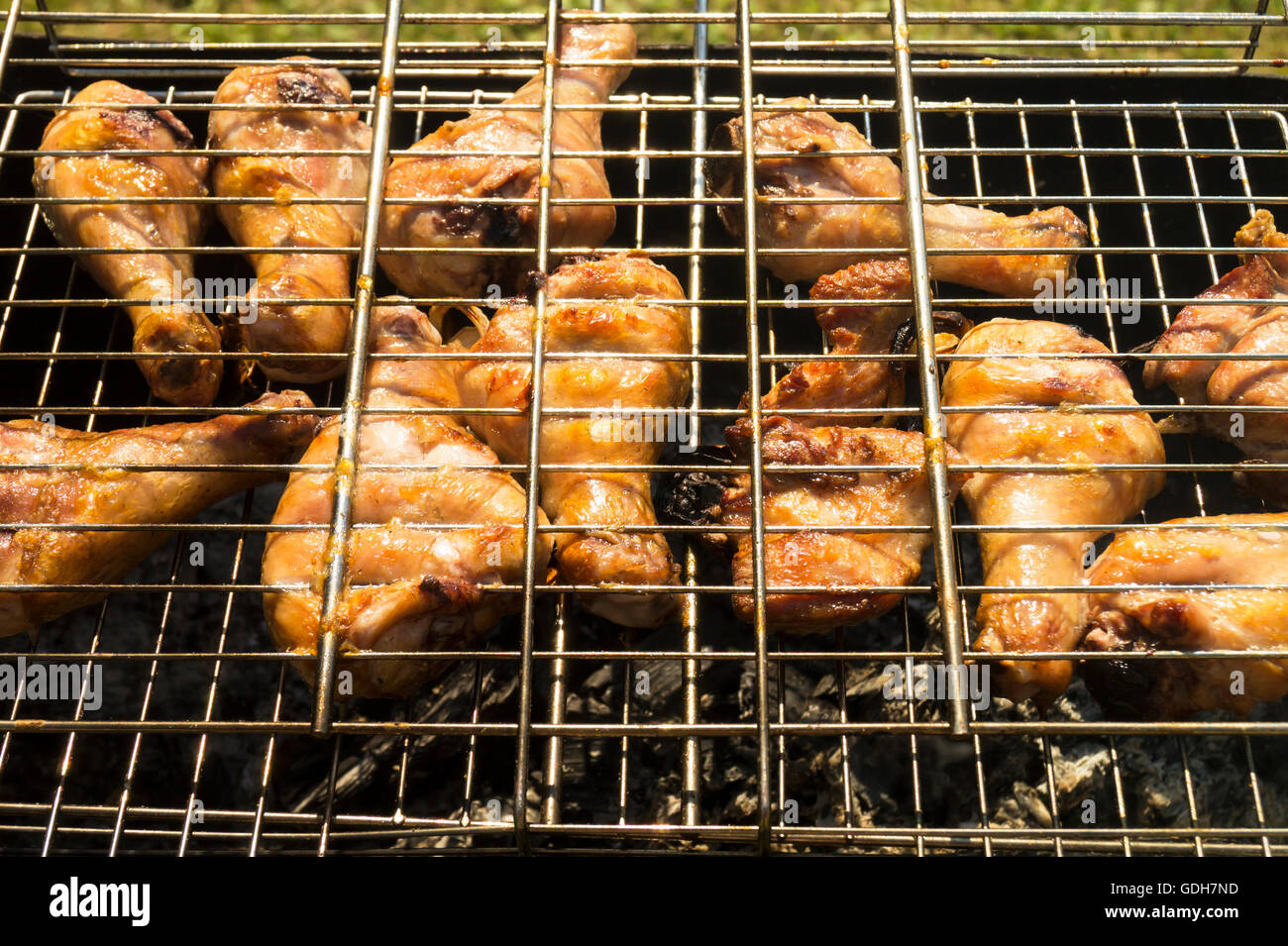 Fleisch der Henne ist auf Stahlnetz auf Holzasche gebraten. Stockfoto