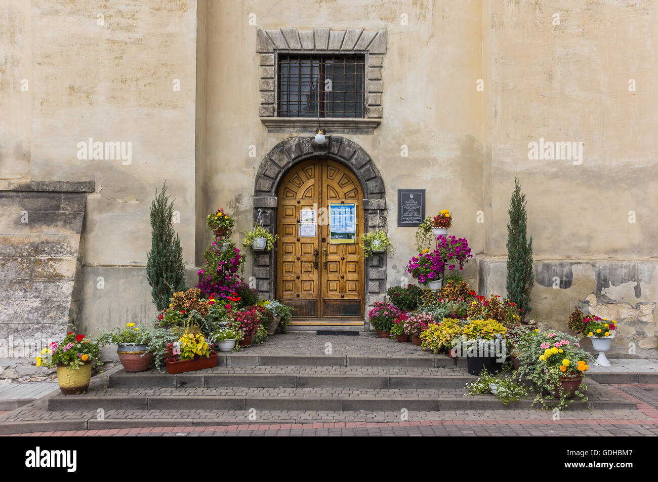 Schritte an eine Kirchentür, dekoriert mit Blumen in Lemberg Stockfoto