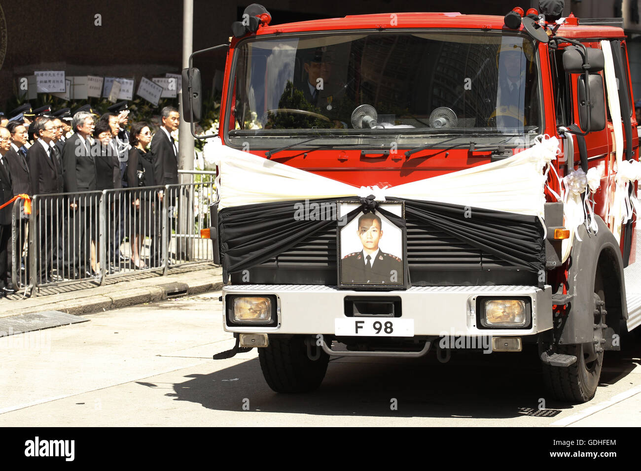 17. Juli 2016 - ein Feuerwehrauto trägt Sarg des späten Feuerwehrmann, Cheung Yu-Sing Abfahrt in Beerdigung Stube bei Hong Kong Regierung, die hohe Beamten stehen auf dem Bürgersteig ihre letzten Respekt (Chief Excecutive C.Y. Leung ist im Hintergrund, zuerst auf der rechten Seite zu sehen). Klasse 4-Feuer brach am 21. Juni 2016, dass gebrannte Industriegebäude in Hong Kong für 4 Tage & Nächte forderte zwei Feuerwehrmänner, es war ein schwersten Feuer überhaupt, das Gebiet in den letzten Jahren zu schlagen. 17. Juli 2016. Hong Kong. Liau Chung Ren © Liau Chung Ren/ZUMA Draht/Alamy Live News Stockfoto