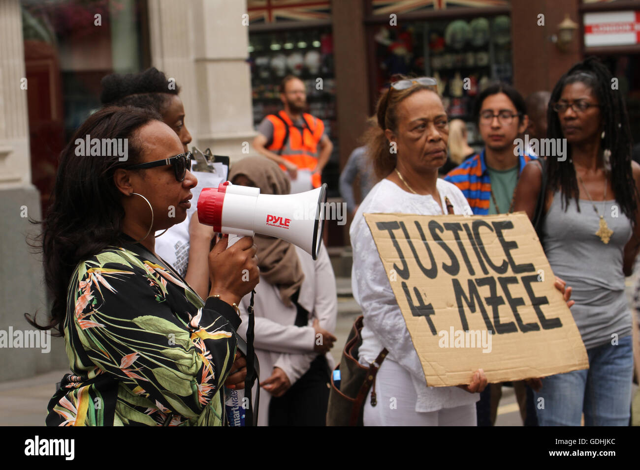 London, UK. 17. Juli 2016. : Ava Morgan ein Freund der Familie von Mzee Mohammed sprechen über ein Mega-Telefon Stephanie Lightfoot-Bennet hält ein Plakat in einer Straße stehen ab in die Black lebt Angelegenheit Demonstranten zu Mzee Mohammed erinnern. Die 18 jährige schwarze Jugend starb in Polizeigewahrsam in Liverpool. Bildnachweis: David Mbiyu/Alamy Live-Nachrichten Stockfoto