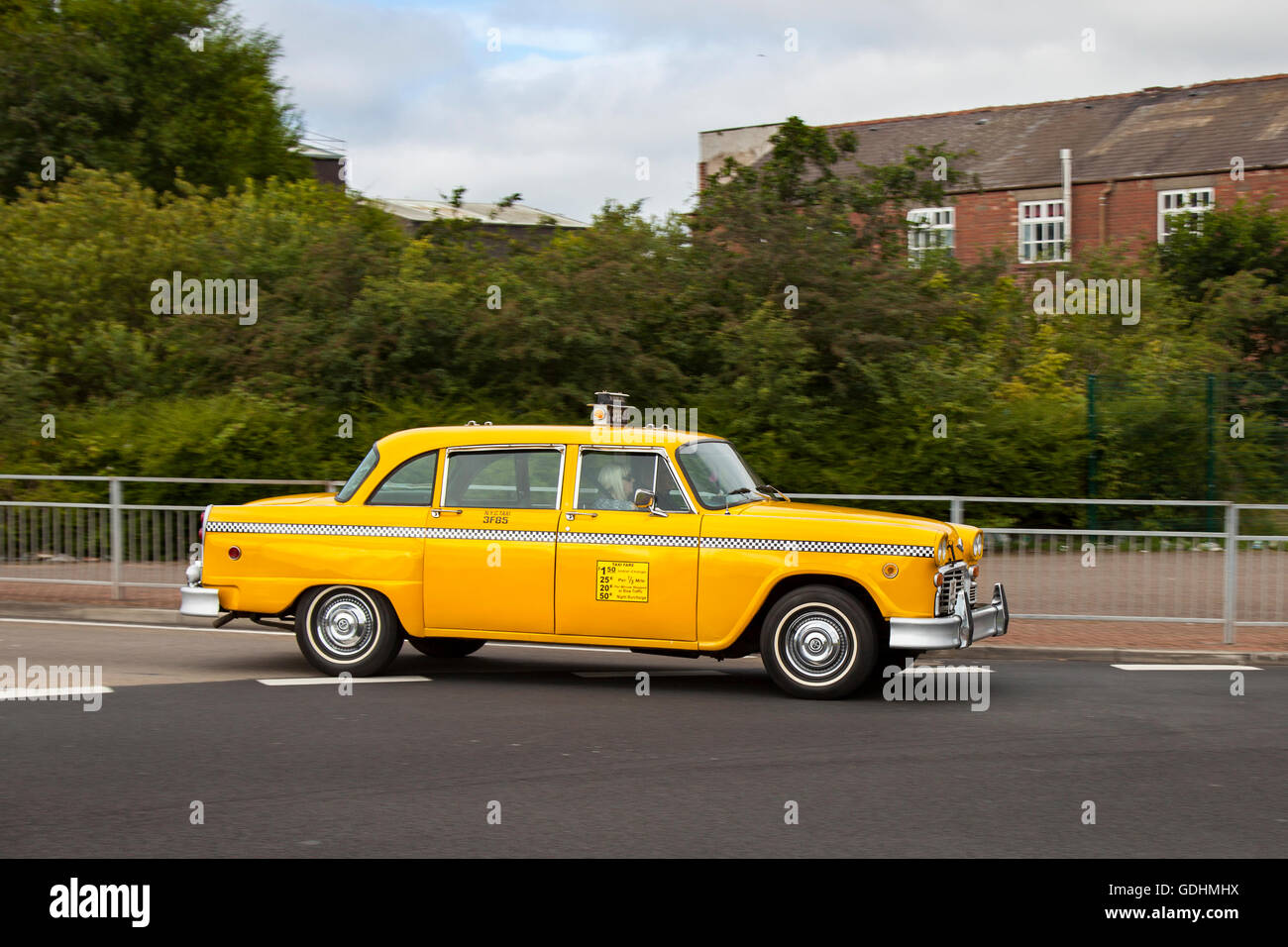 Das Checker Cab Gelbe lackierte US-Autos in Fleetwood, Lancashire, Großbritannien. Juli 2016. Ray Tomkinson mit seinem amerikanischen Taxi (Taxifahrer der Vereinigten Staaten) beim Festival of Transport in der Küstenstadt. Dieses alte US-Taxi wurde vor 17 Jahren von Ray importiert und hat sich sowohl bei Veranstaltungen in der Filmwelt als auch bei Veranstaltungen, bei denen seine Americana-Fahrzeuge in Casino Royal, Kick ASS2, Batman Forever und Dark Shadows eingesetzt wurden, als Hit erwiesen. Stockfoto