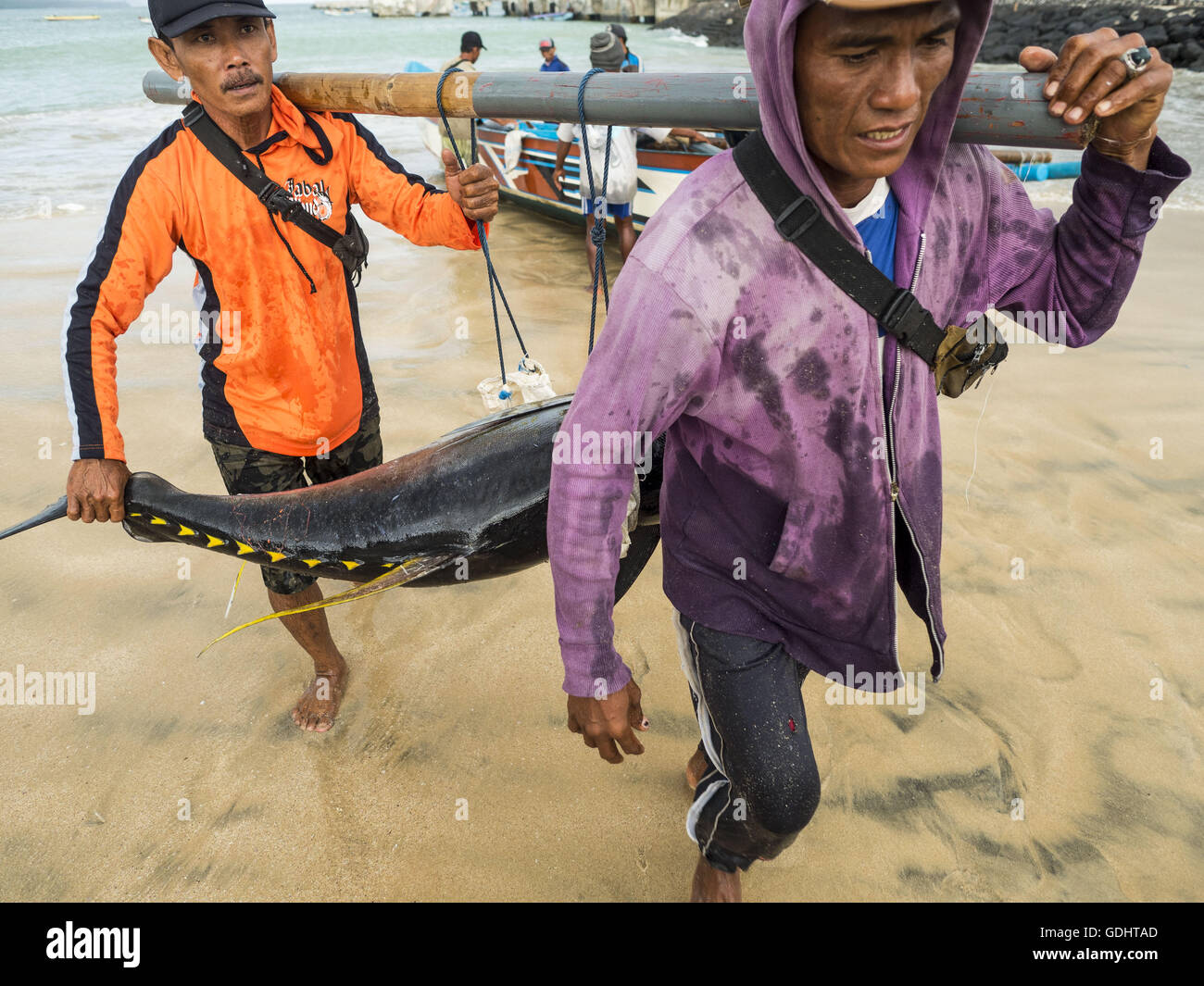 Kuta, Bali, Indonesien. 18. Juli 2016. Arbeiter tragen Gelbflossenthun auf Käufer warten, wiegen und der Fisch am Pasar Ikan Pantai Kedonganan, einem Angelpier und Markt in Kuta, Bali zu benoten. Yellowfin sind sehr beliebt bei japanischen Konsumenten für Sushi und Sashimi und die besten Yellowfin in indonesischen Gewässern gefangen werden direkt nach Japan geschickt. Bildnachweis: Jack Kurtz/ZUMA Draht/Alamy Live-Nachrichten Stockfoto