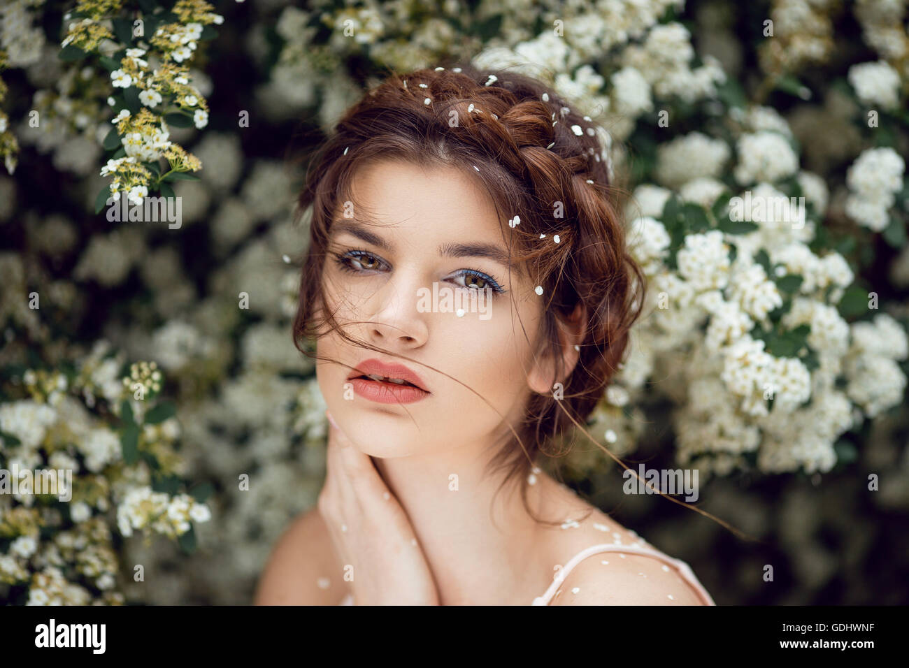 Mode-Porträt einer schönen jungen Frau vor einem weißen Blüten Stockfoto