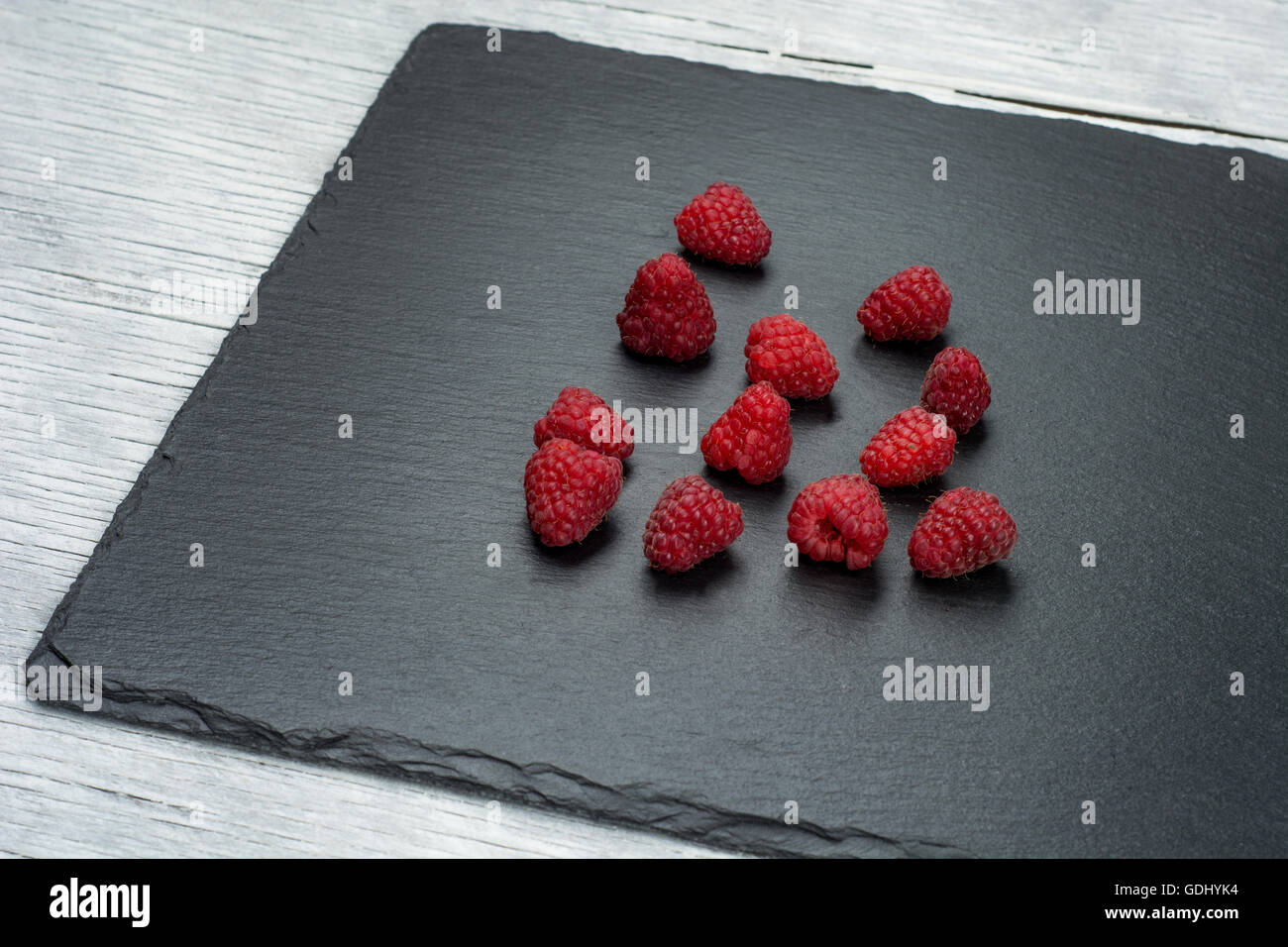 Himbeer Dessert und frische Himbeeren auf einem schwarzen Holztisch rohe Kuchen Stockfoto