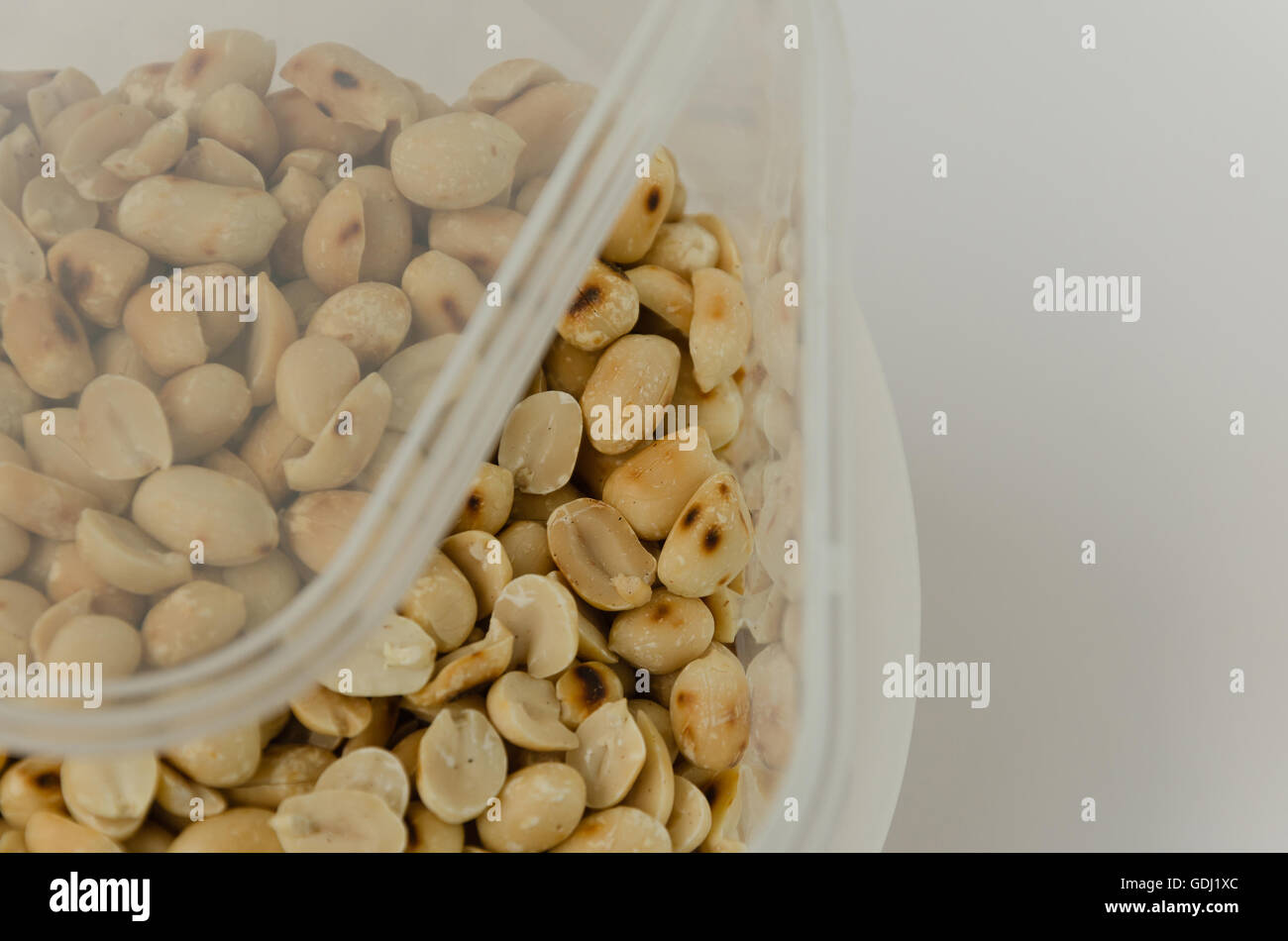 Erdnuss In Kunststoff-Box Container auf weißem Hintergrund. Stockfoto