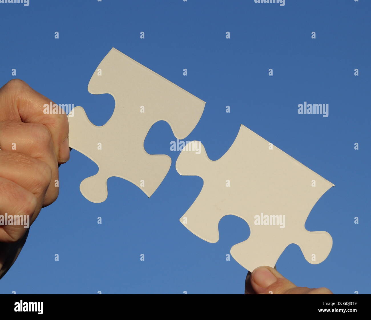 Weibliche Finger halten Puzzleteile Stockfoto