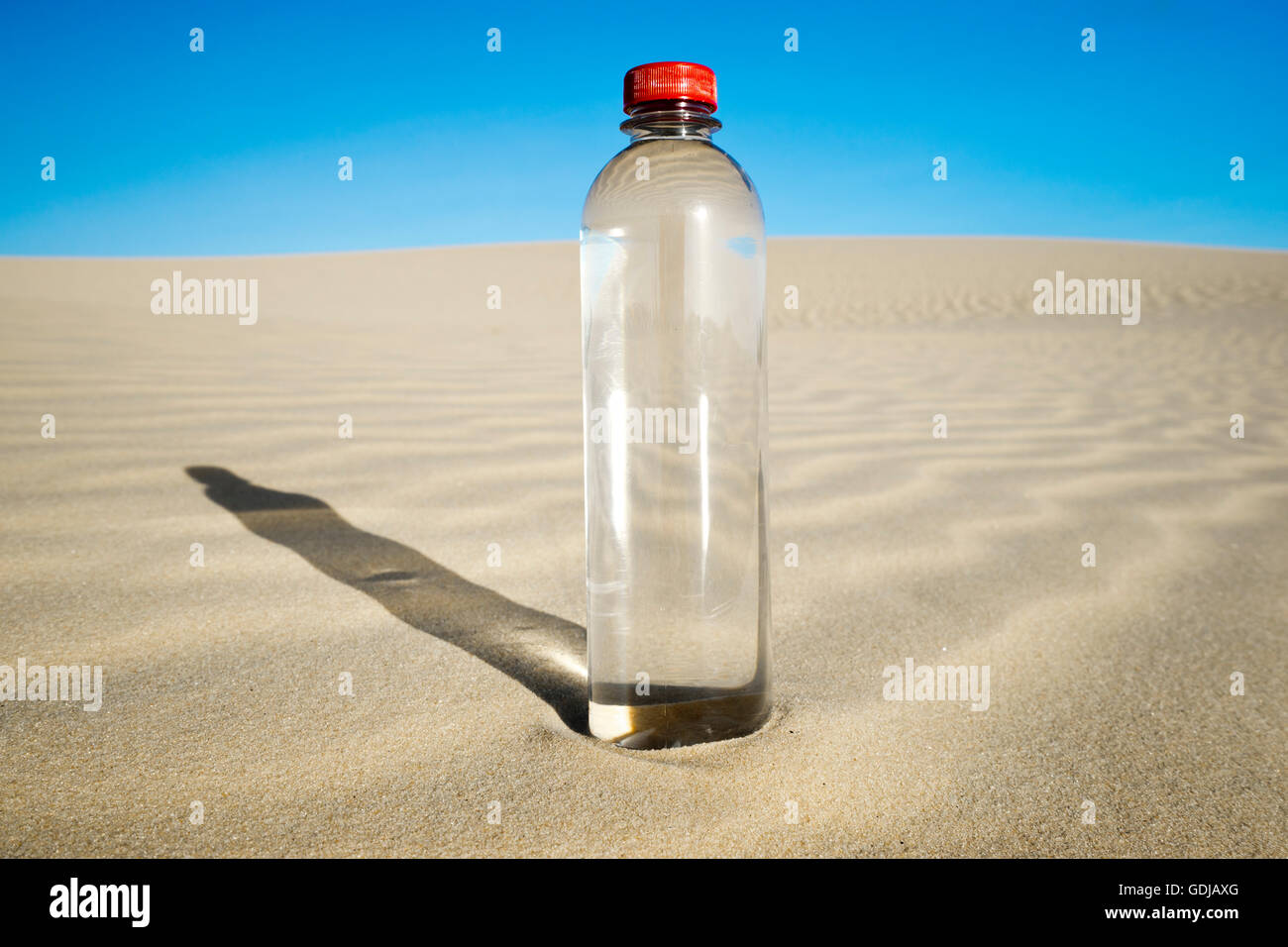 PET Flasche Wasser in Wüstenlandschaft Stockfoto
