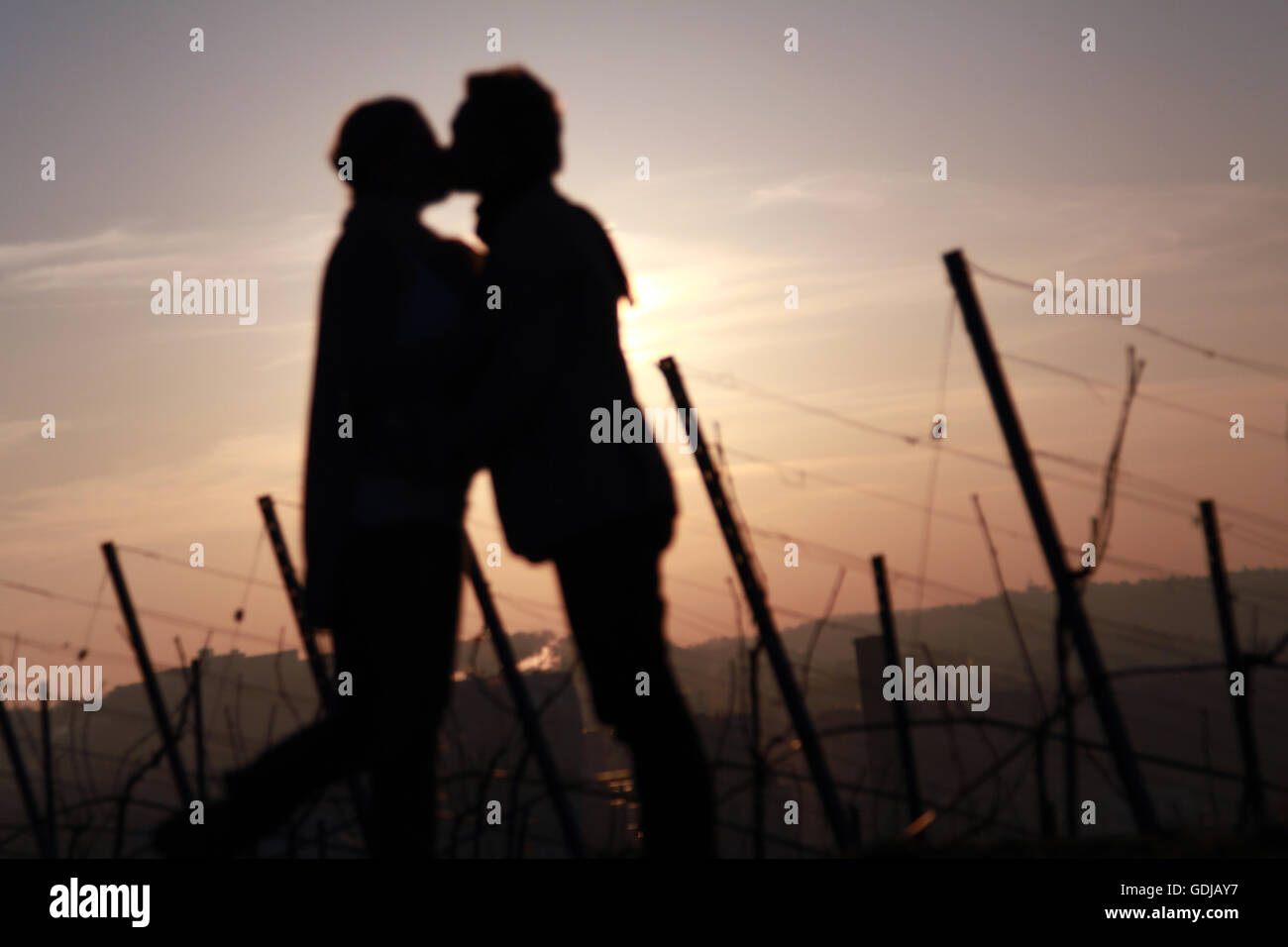 verschwommen Sillhouette verliebte Paar küssen und halten Hände in wunderschönen Sonnenaufgang Stockfoto