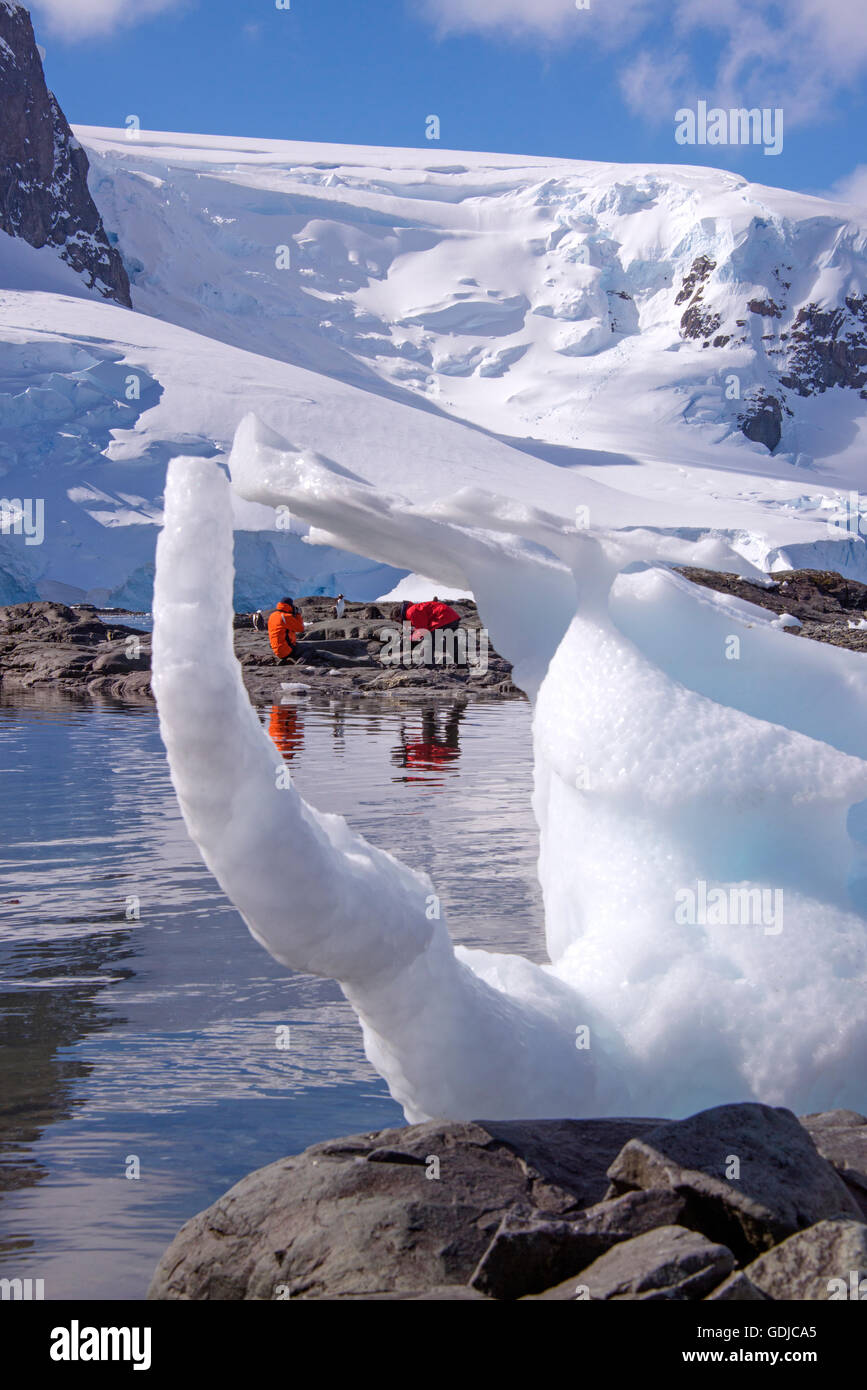 Touristen sitzen auf einem Strand umgeben von Gletschern in der Antarktis Stockfoto