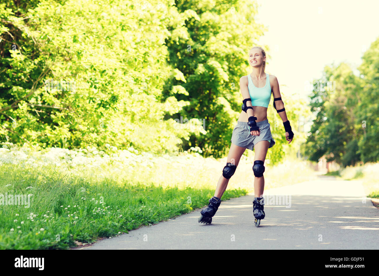 glückliche junge Frau in Rollerblades fahren im freien Stockfoto