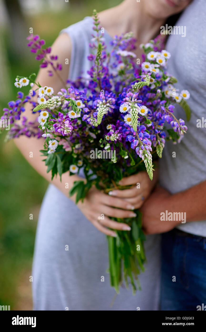 Mann und Frau treffen sich im Park mit Blumenstrauß Stockfoto