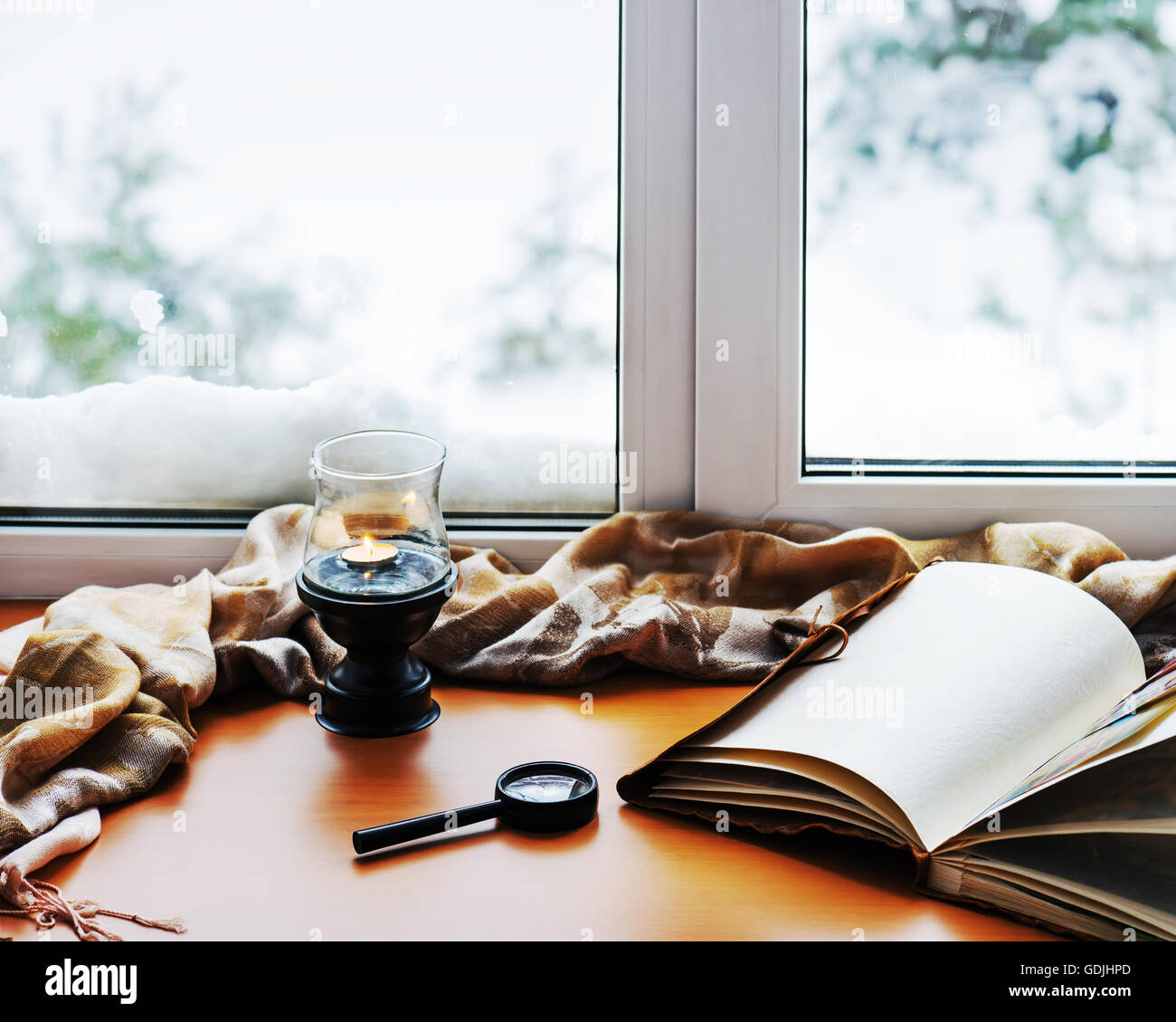 Öffnen, Fotoalbum, Kerze, Lupe und und Beige warmen Plaid befindet sich auf einer stilisierten hölzerne Fensterbank. Winter-Konzept von c Stockfoto Öffnen, Fotoalbum, Kerze, Lupe und und Beige warmen Plaid befindet sich auf einer stilisierten hölzerne Fensterbank. Winter-Konzept von c Stockfoto