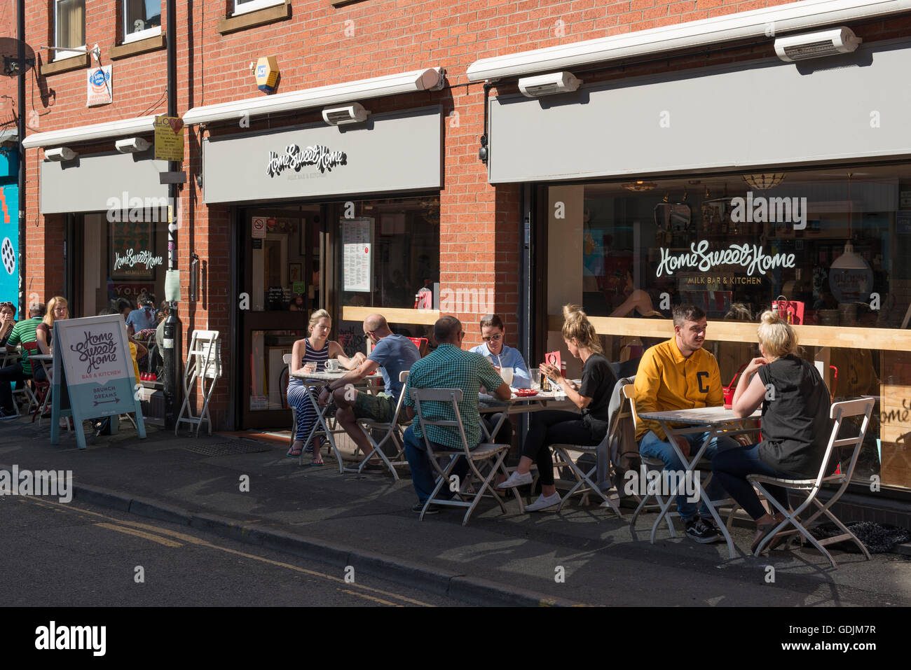 Menschen, die einen Drink außerhalb Home Sweet Home befindet sich am Rand Straße in die Northern Quarter Viertel von Manchester. Stockfoto