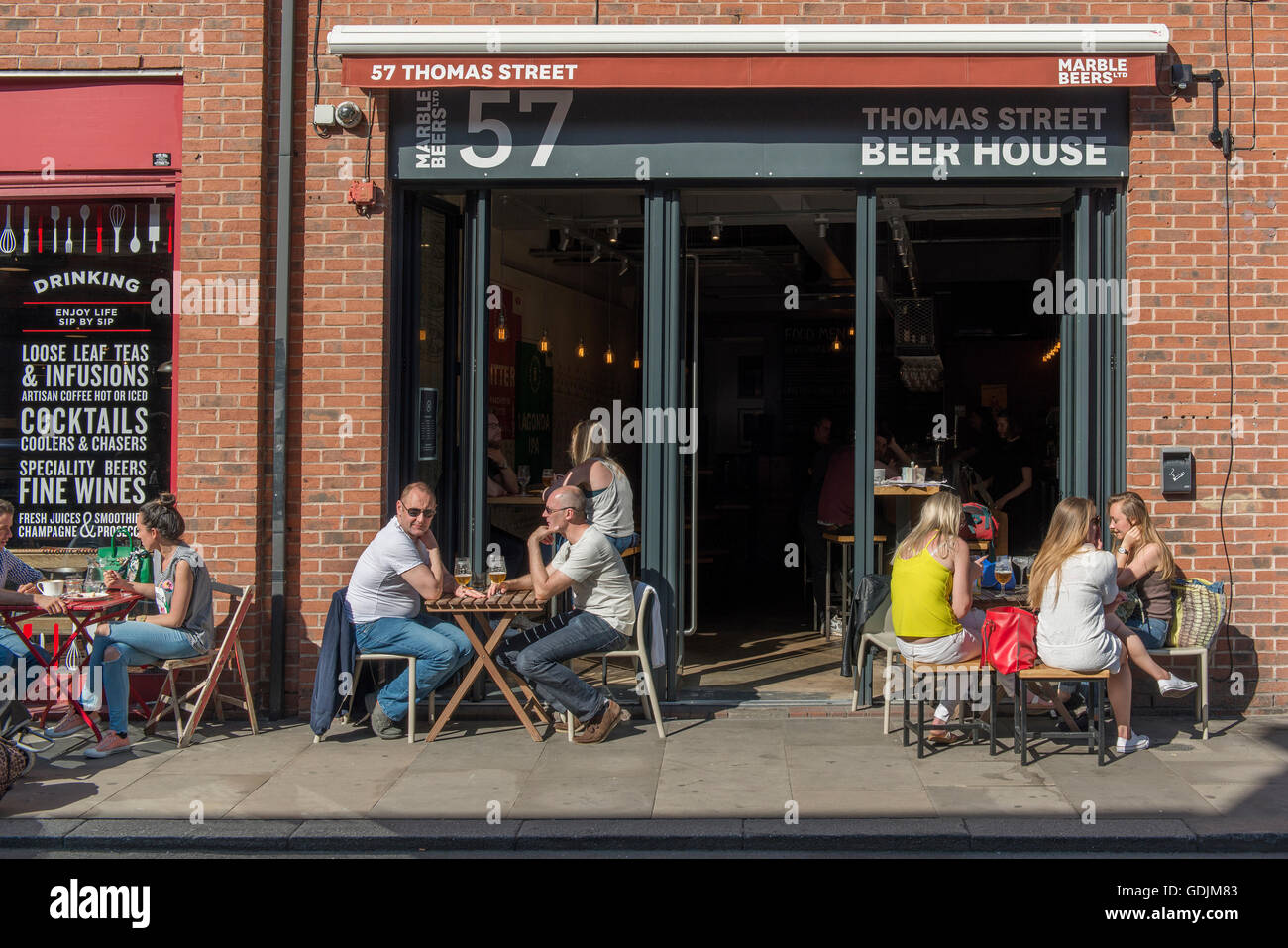 Menschen, die einen Drink vor Thomas Street Bierhaus befindet sich in Northern Quarter von Manchester. Stockfoto