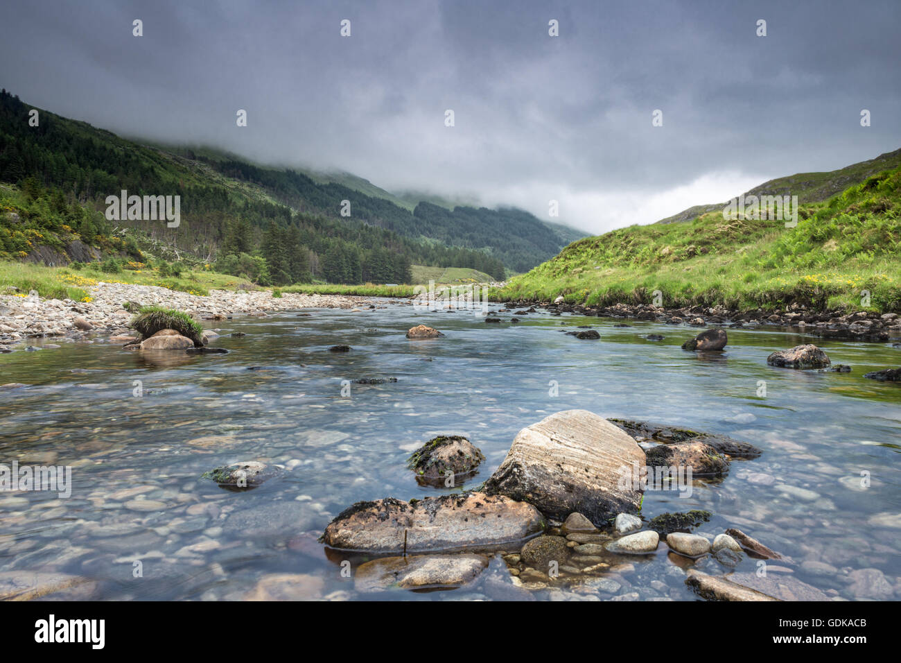 Regnerischen Wolken über Crystal Clear River unter den schottischen Highlands Stockfoto